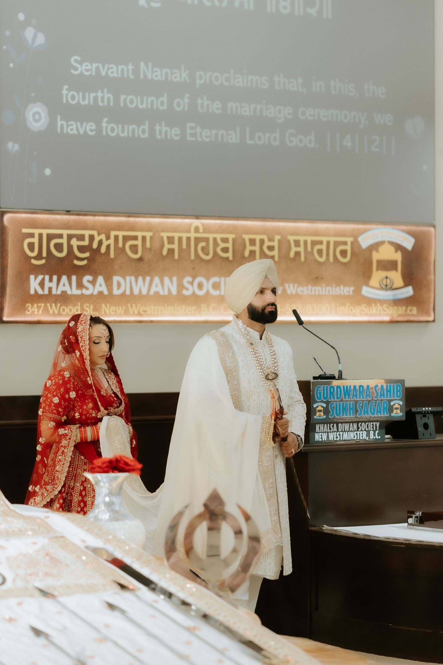 Sikh couple in traditional attire during Anand Karaj wedding ceremony at Khalsa Diwan Society Gurdwara.