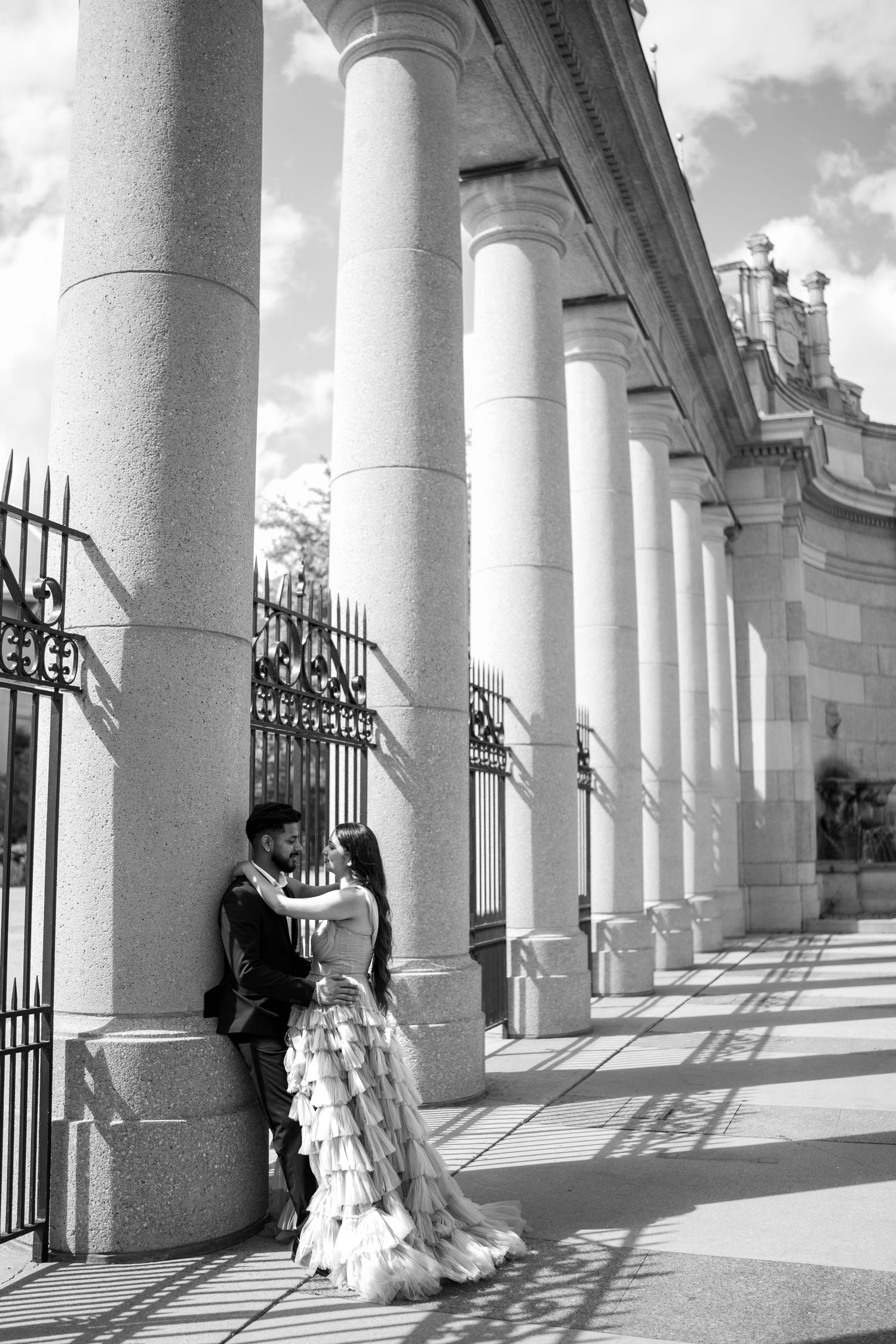 A romantic photo sequence under classical white columns casting dramatic shadows.