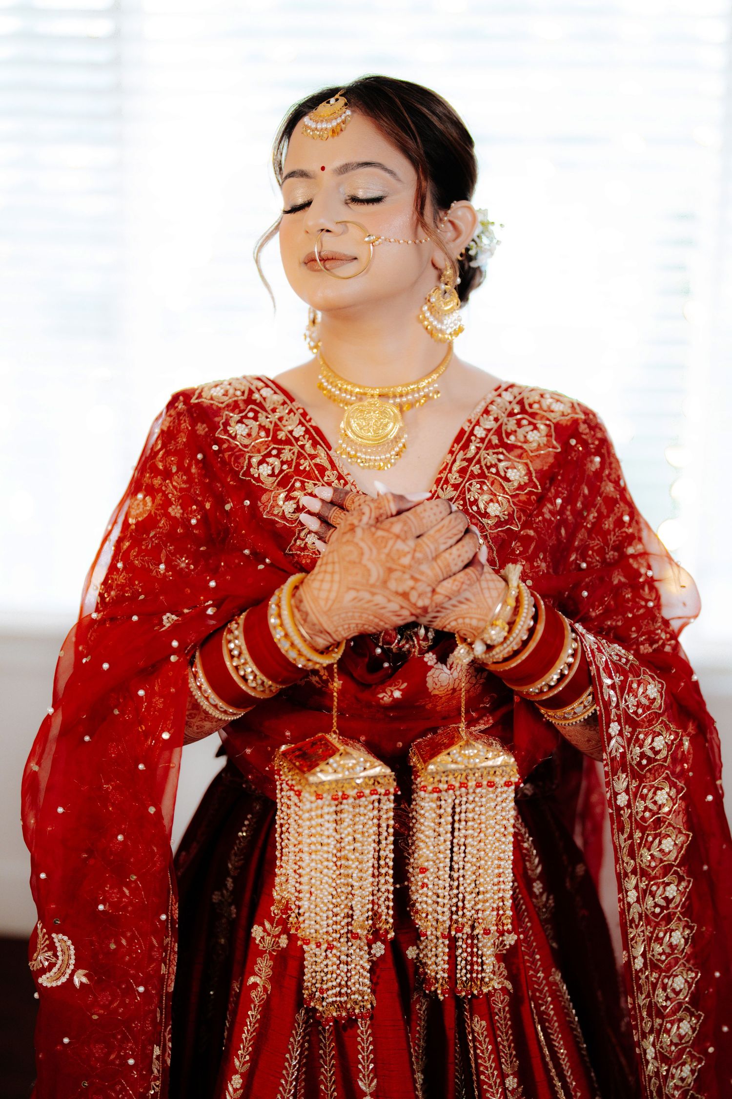 Traditional Indian bridal attire featuring gold kalire and detailed embroidery on red fabric.
