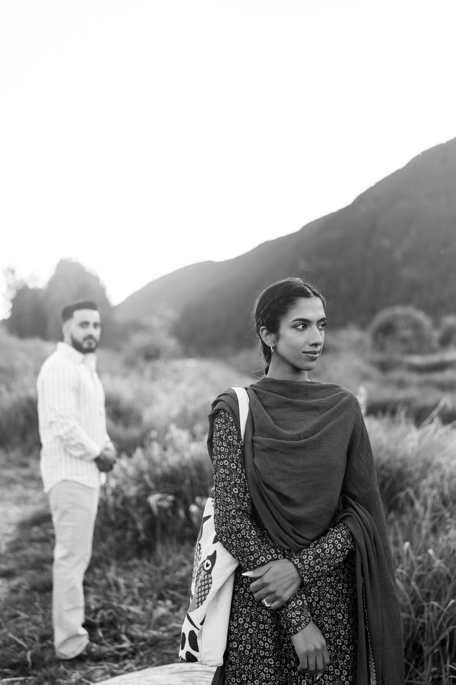 A series of black and white photographs showing a woman in traditional dress with a dark shawl in an outdoor setting.