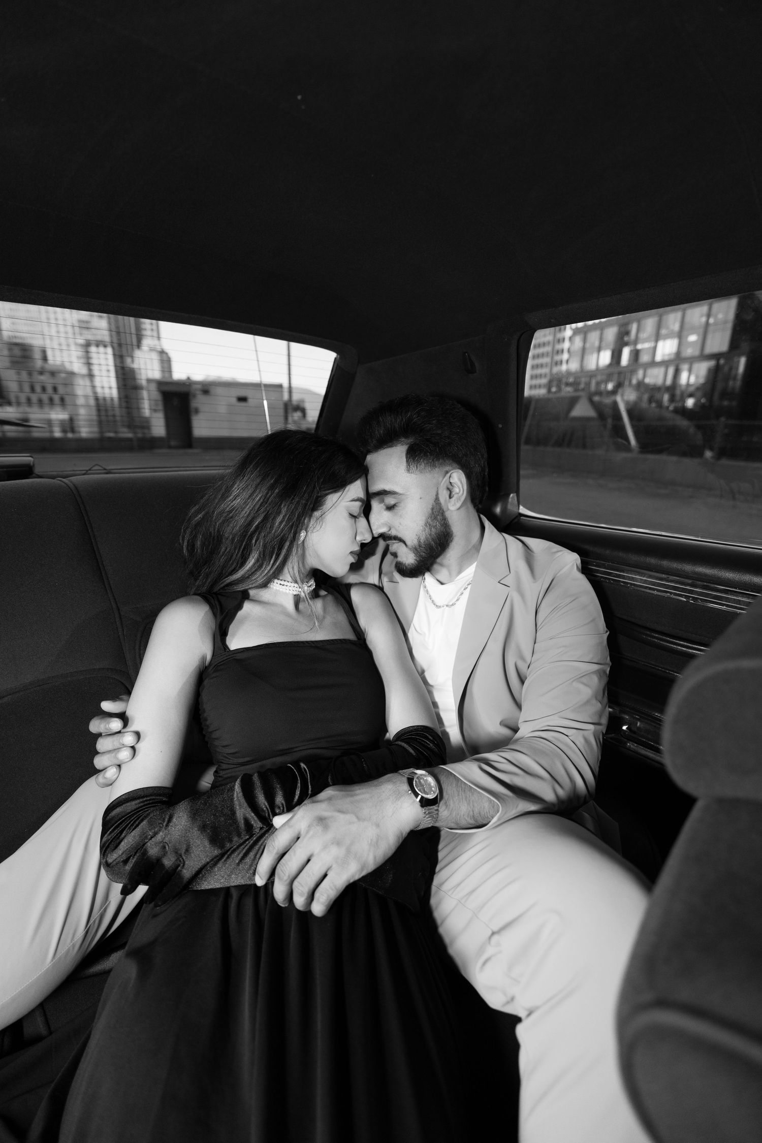 Black and white photo series showing an intimate moment between a couple in the backseat of a car.