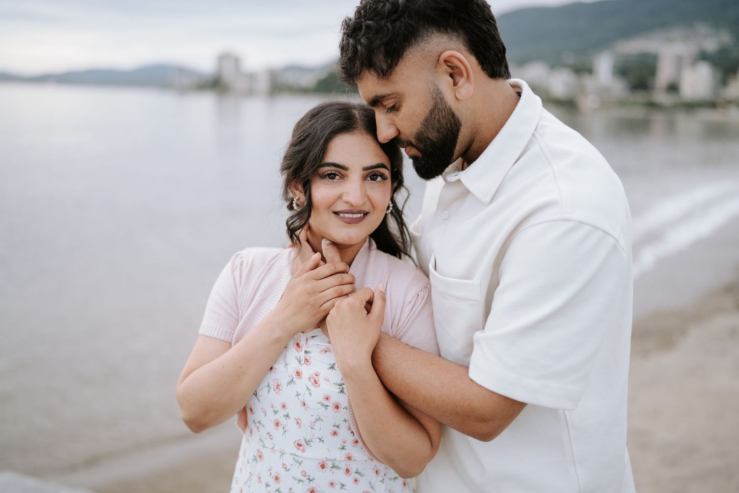 A couple shares an emotional moment together during a beach photoshoot.