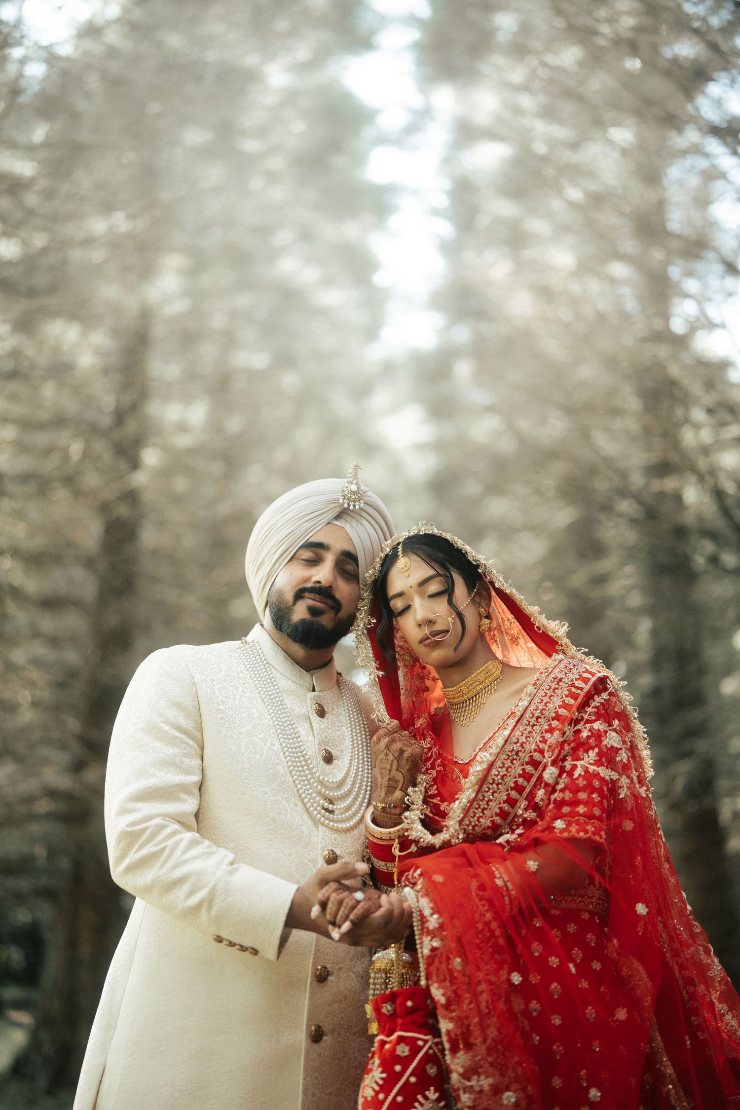 Romantic wedding portraits in a misty forest setting with traditional Sikh and Indian attire.