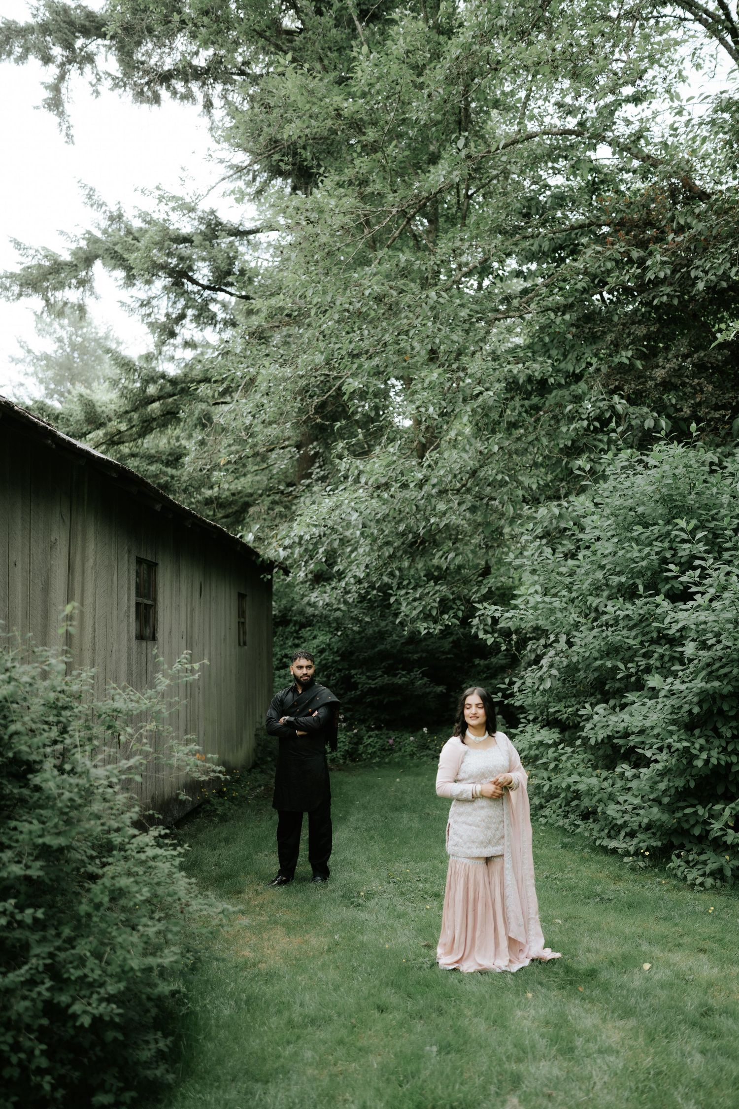 Artistic engagement photos taken in a natural setting with rustic barn backdrop.