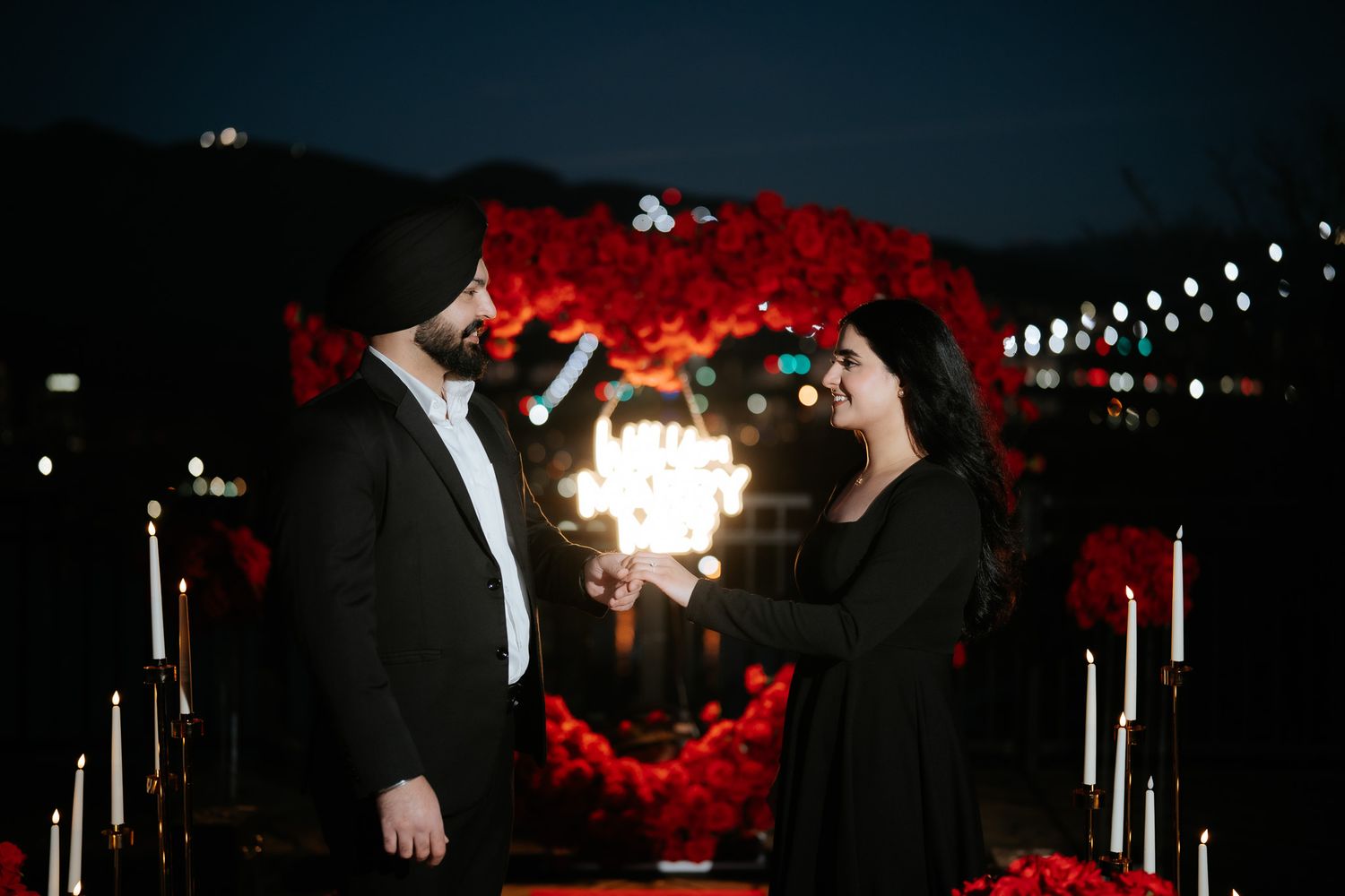 Silhouetted figures dance under string lights at a nighttime outdoor celebration with red lighting accents.