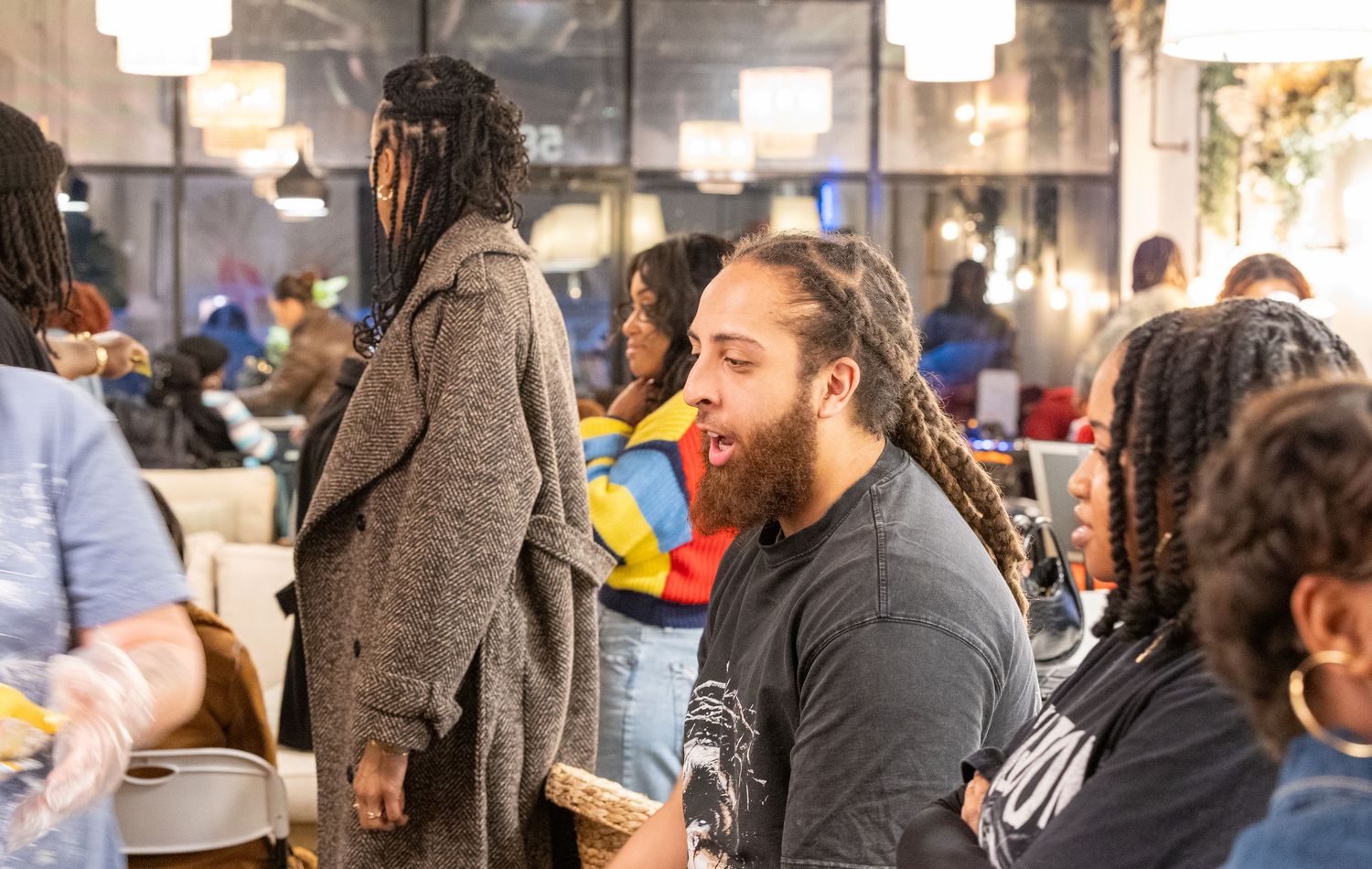 Diverse group of people socializing and laughing at an indoor gathering event in a modern space.
