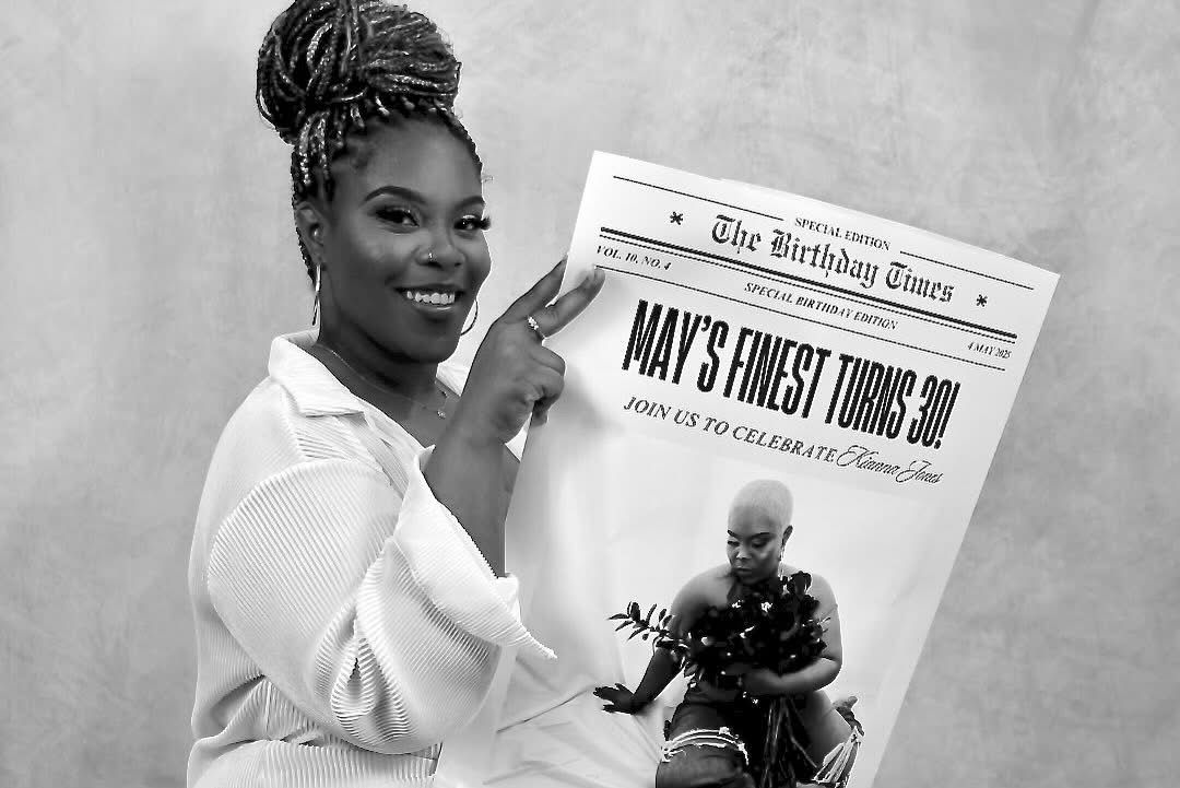 Woman holding birthday newspaper prop celebrating 30th birthday in black and white portrait photo.