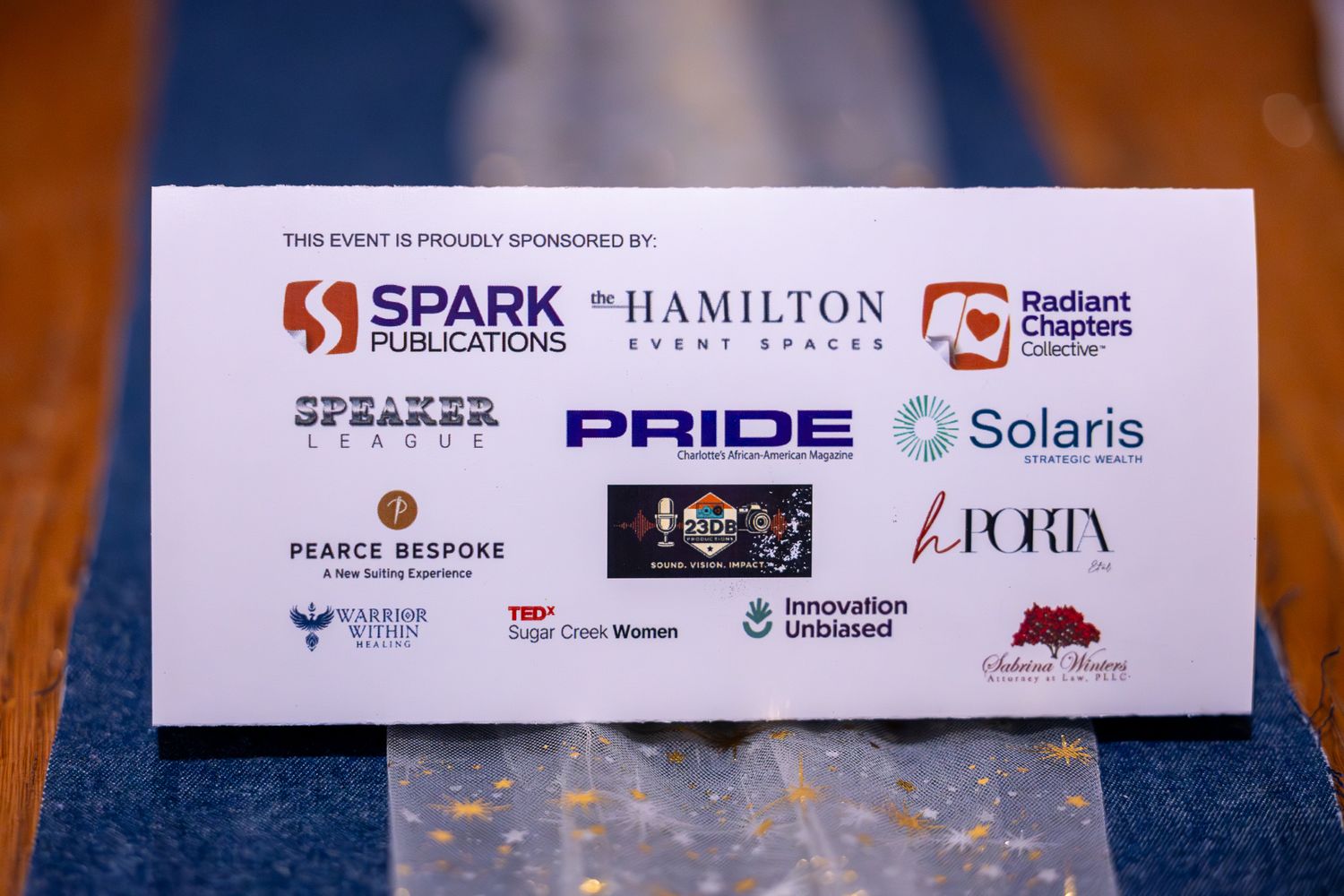 Event sponsor board featuring logos including Spark Publications, Hamilton Event Spaces, Pride, Solaris, and Pearce Bespoke.