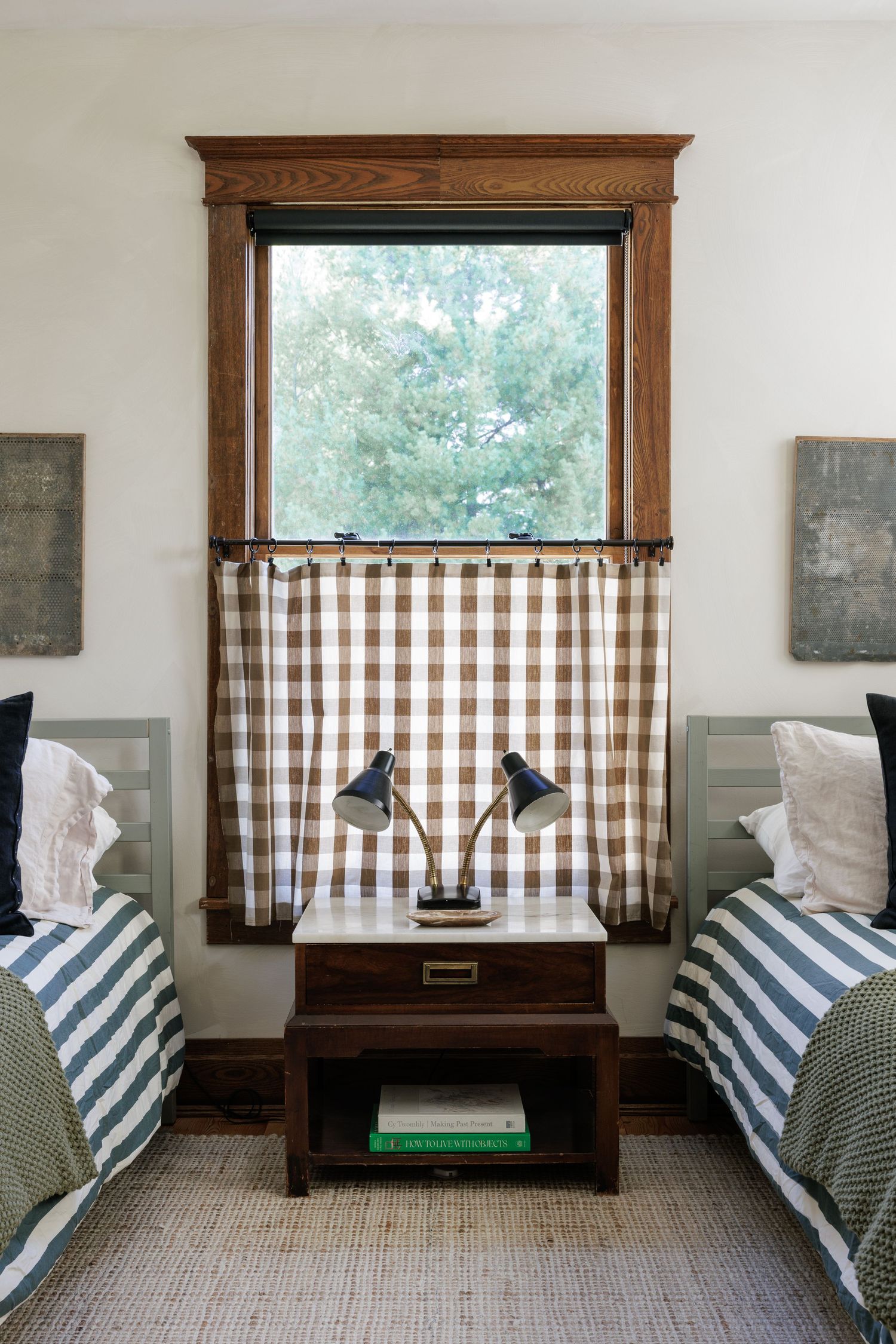 Window seat with striped cushions and gingham curtains in a bright, modern room.