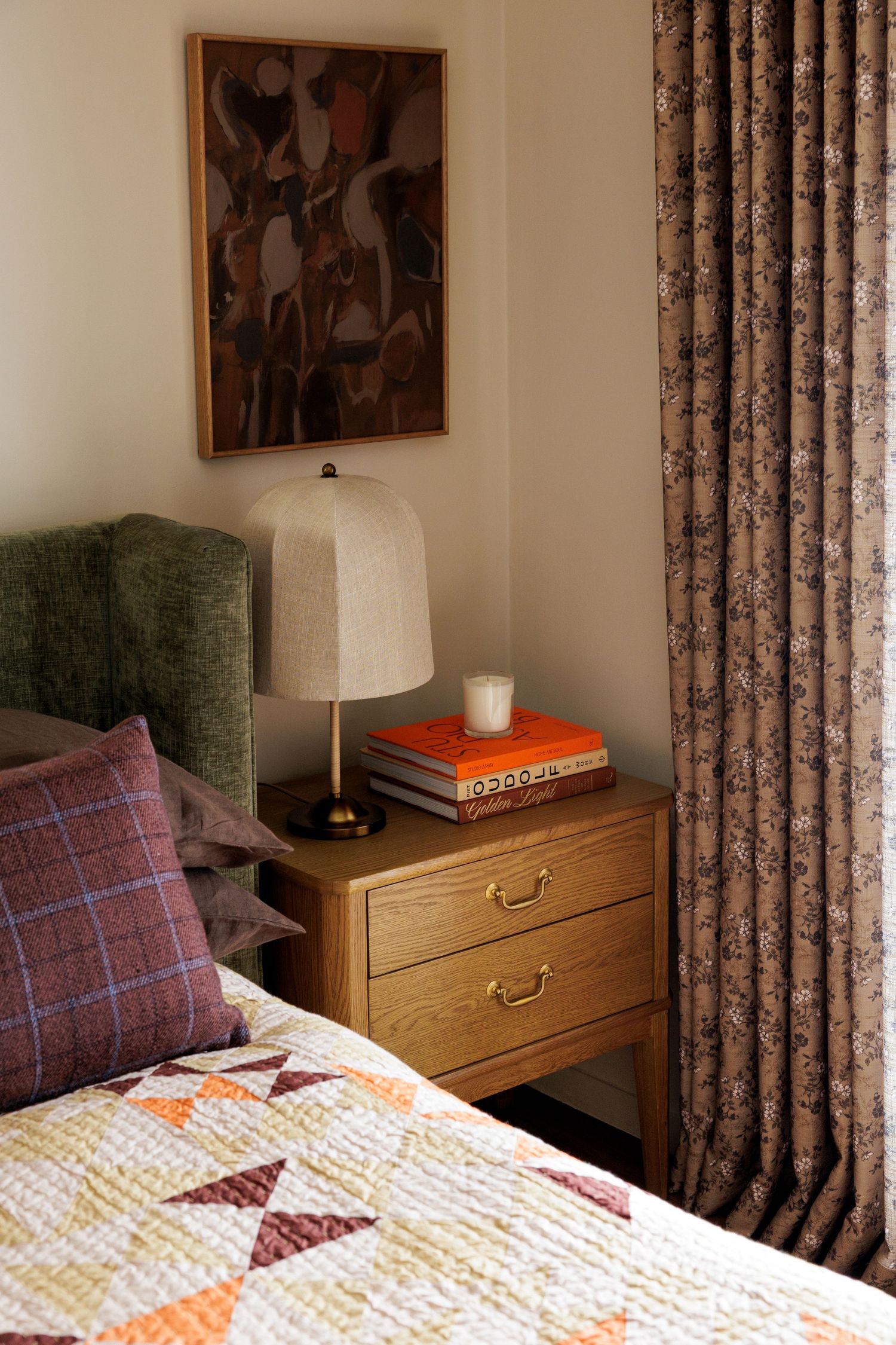 Bedroom detail showing patterned curtains, wooden dresser, and geometric bedding.