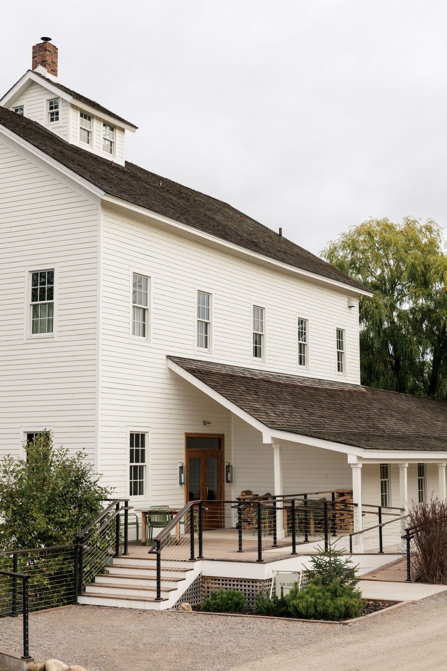 Modern white farmhouse exterior with accessible ramp and contemporary metal railings.