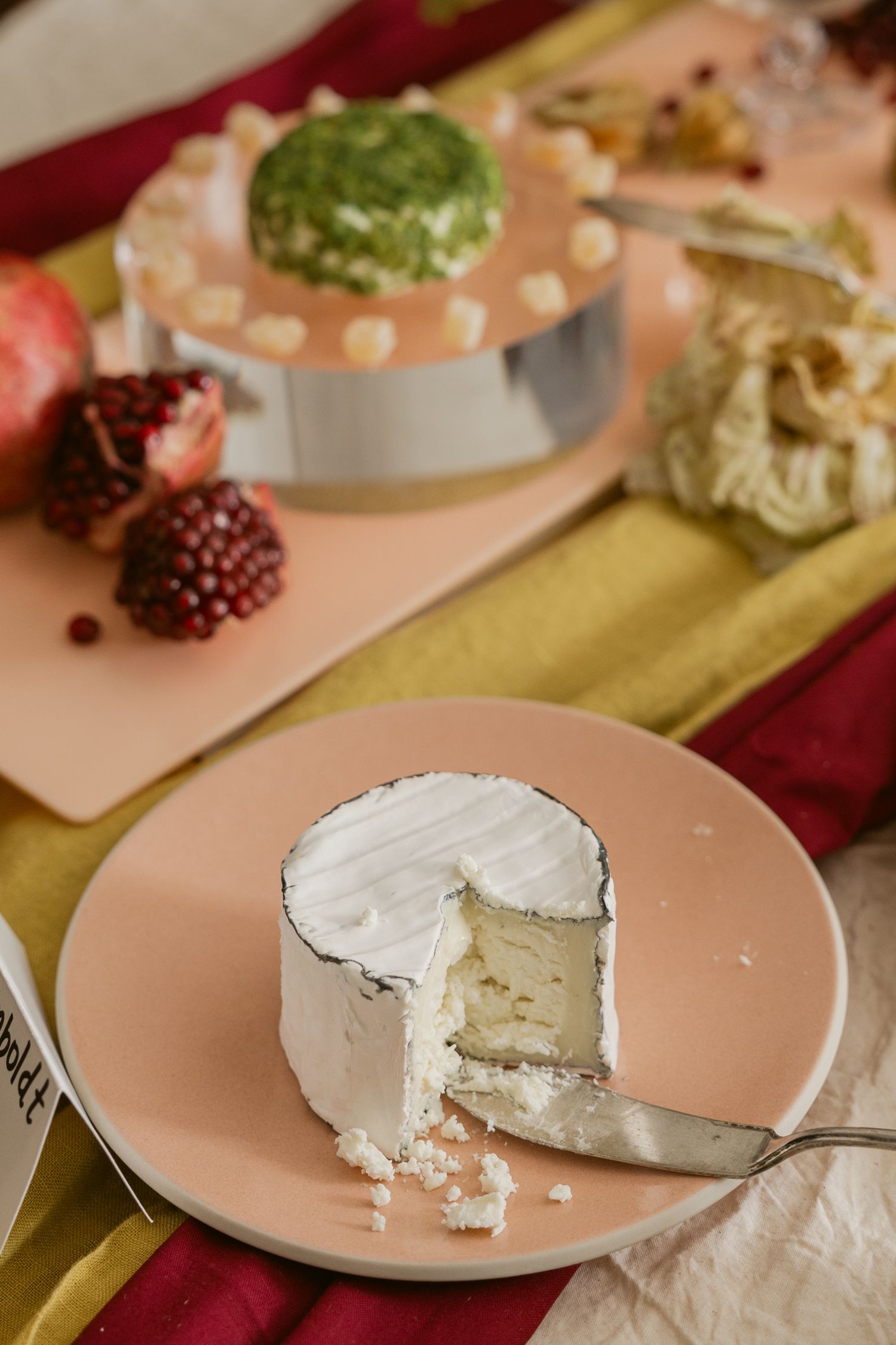 Plates of creamy white cheese with bites taken out arranged on pink dishes.