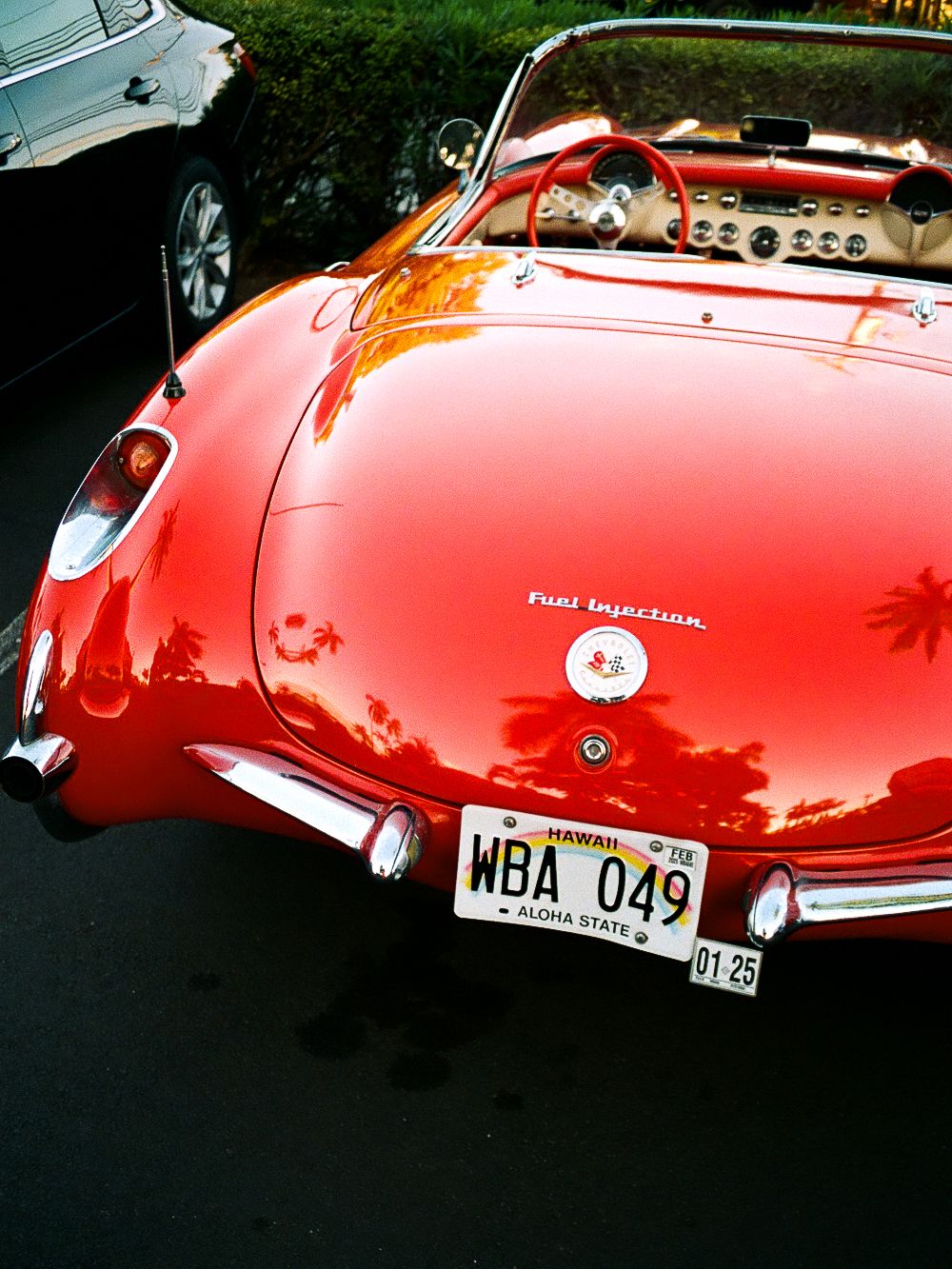 Vintage red convertible sports car photographed from rear angle showing classic details.