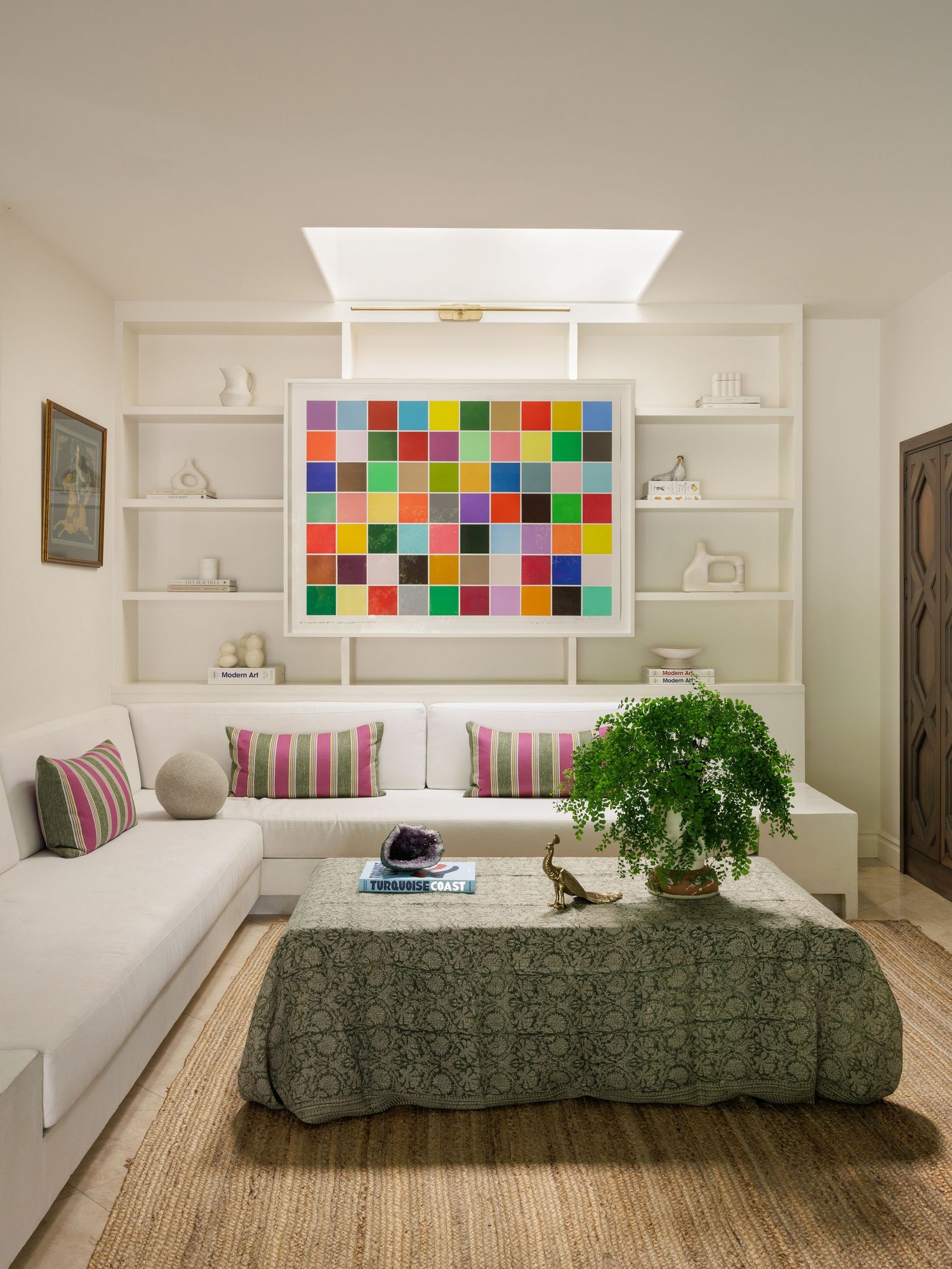 Modern living space with built-in shelving, colorful wall art and comfortable seating area.