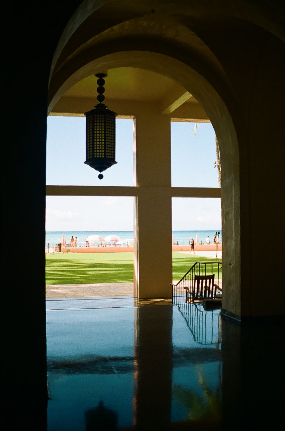 Arched colonnade framing an ocean view with dramatic lighting and architectural details.