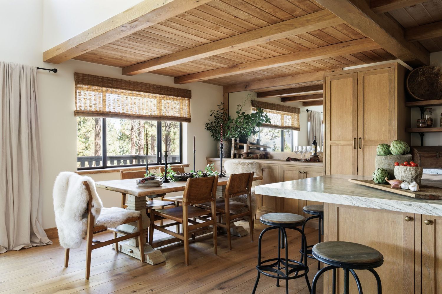 Modern open concept living room with exposed wooden beams, floor-to-ceiling windows, and minimalist Scandinavian decor.