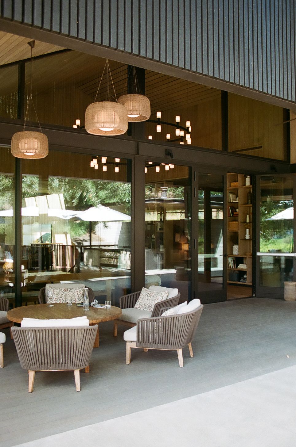 Modern lounge area with comfortable seating and pendant lighting in an open-air setting.