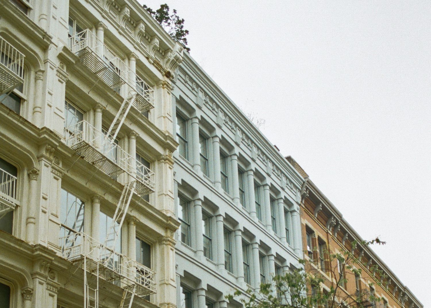 Ornate historic building facades with classical architectural details and balconies along a city street.