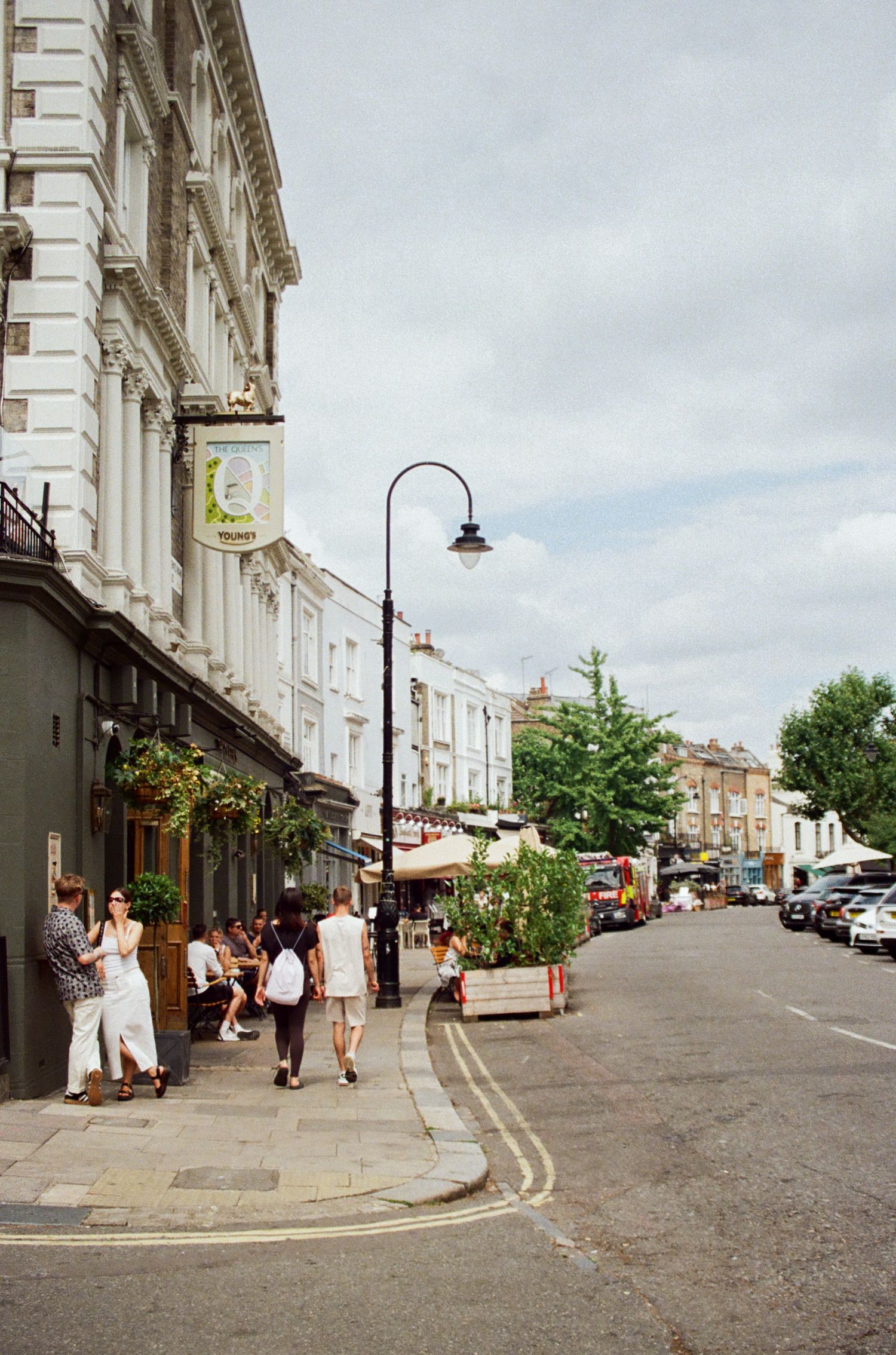 Historic street with classic architecture and pedestrians walking along storefronts.
