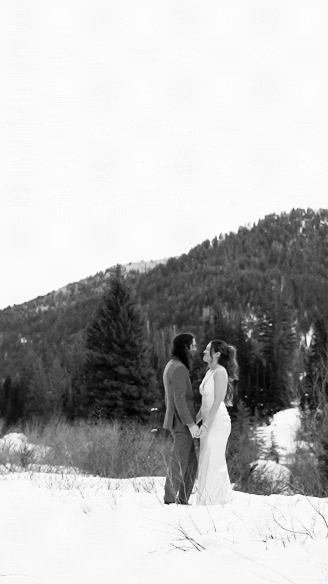 Romantic couple eloping sharing tender moments against a snowy winter landscape.