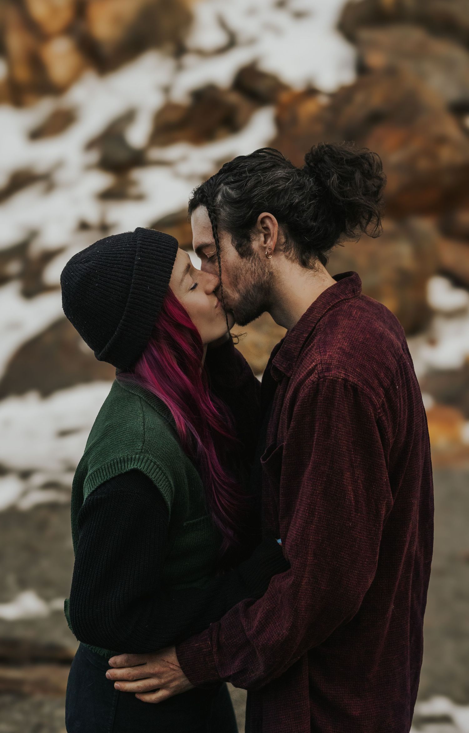 Romantic couple sharing tender moments against a snowy winter landscape.