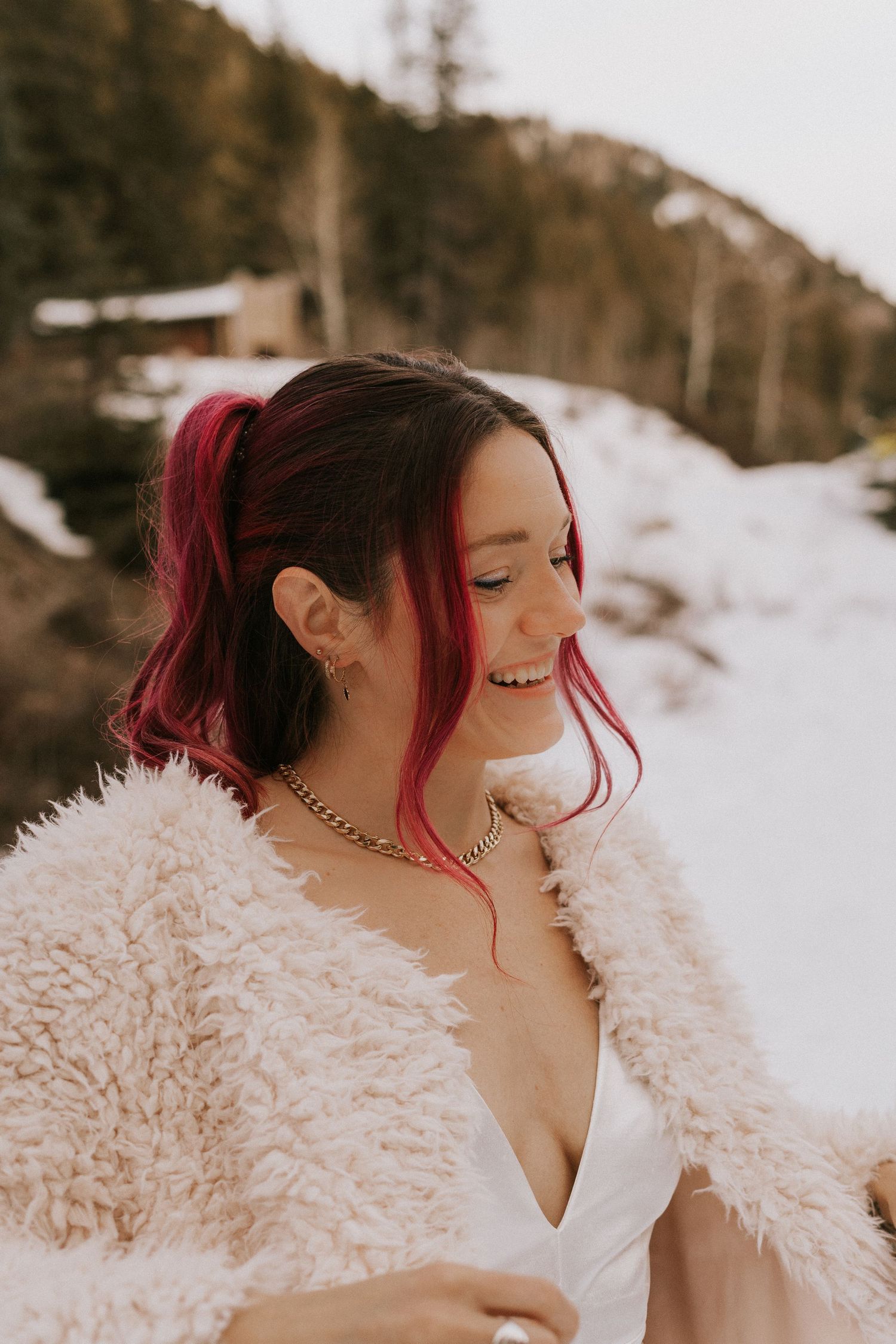 Winter bridal portrait featuring a cozy fur jacket and vibrant hair styling.