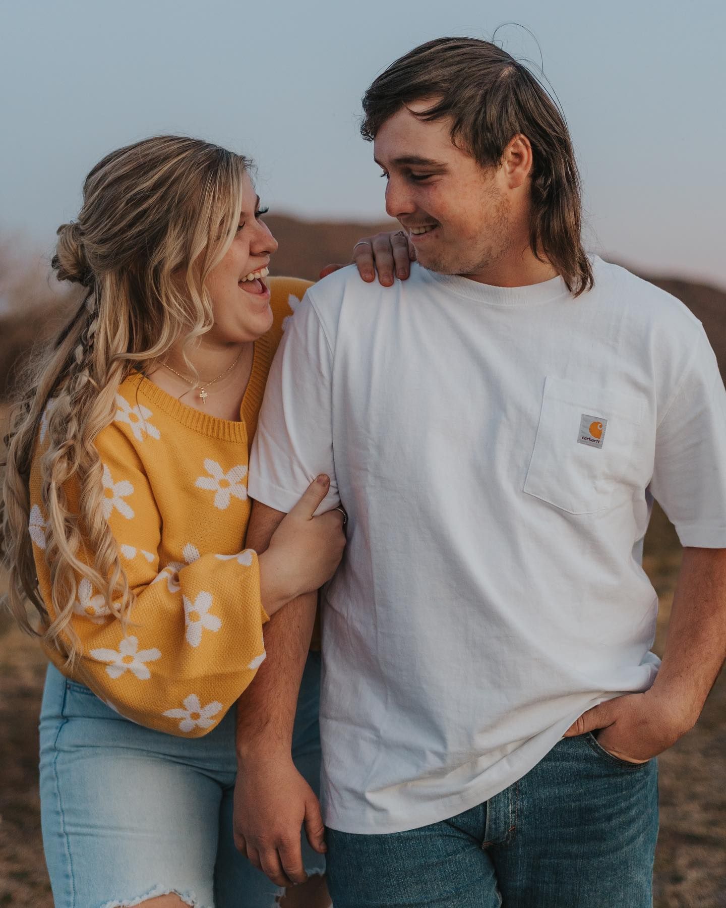 Couple in casual summer outfits sharing intimate moments during outdoor photoshoot.
