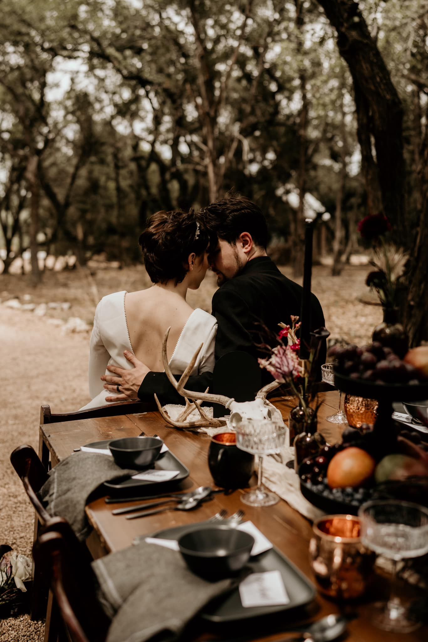 Intimate outdoor dinner setup with rustic table settings and autumn decor.