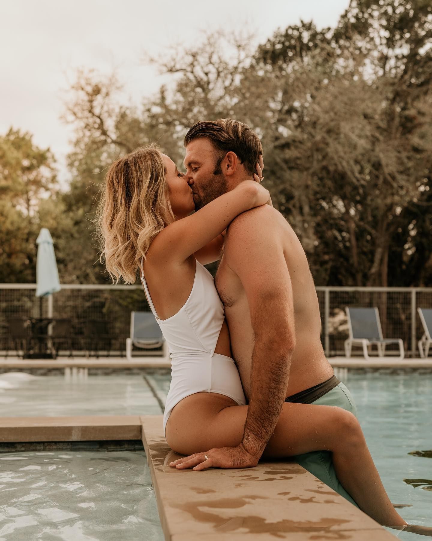 Romantic poolside photoshoot with couple sharing intimate moments at sunset.
