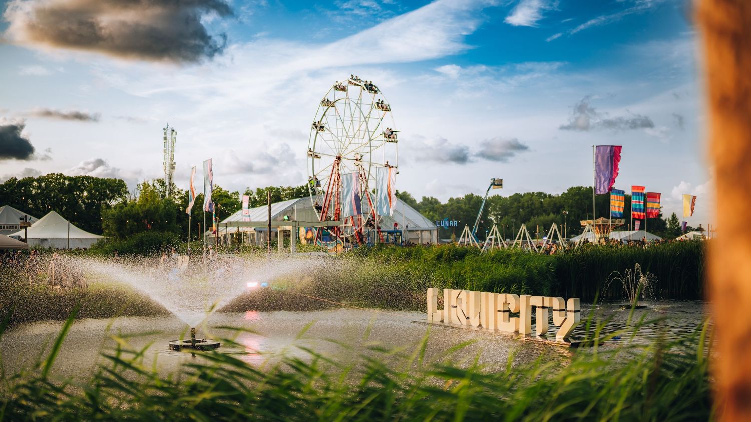 Outdoor festival site with ferris wheel and water fountain