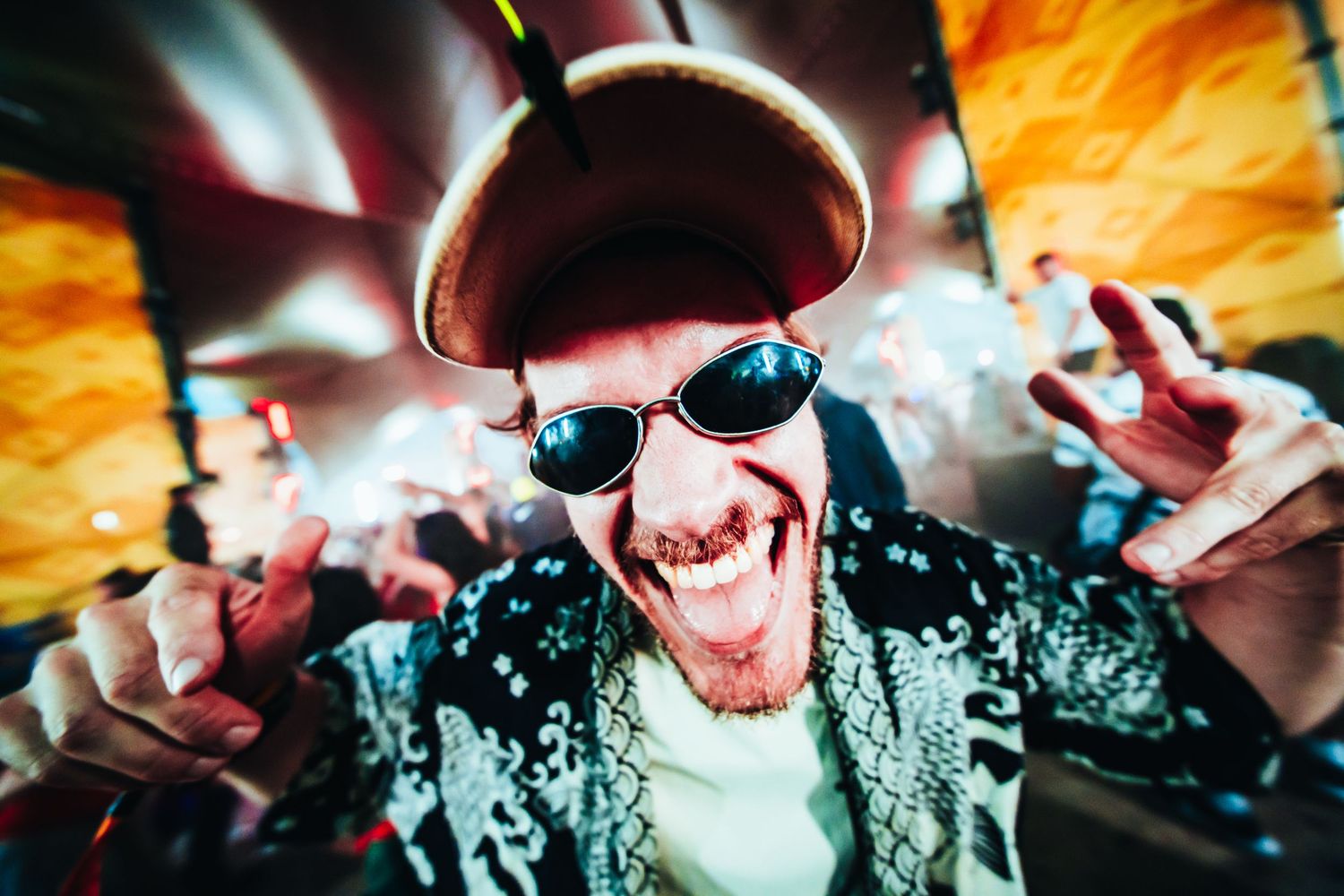 Festival portrait of dancing man in crowd with sunglasses