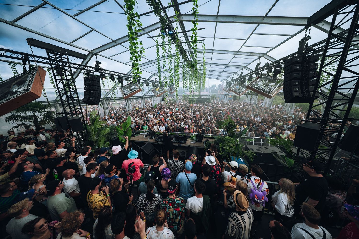 Large crowd dancing under festival tent