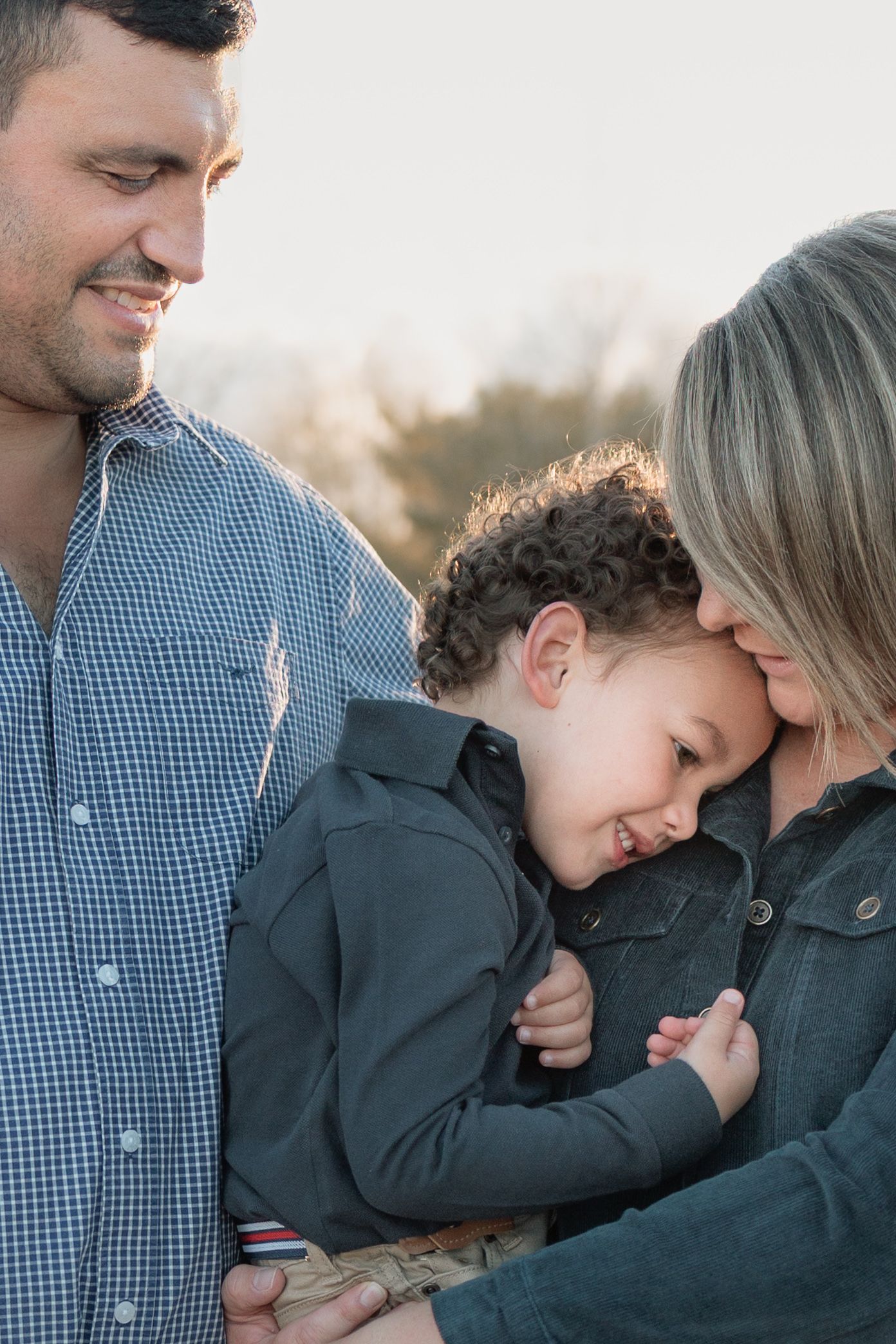Young family laughing together in golden hour light, Inverell family photographer