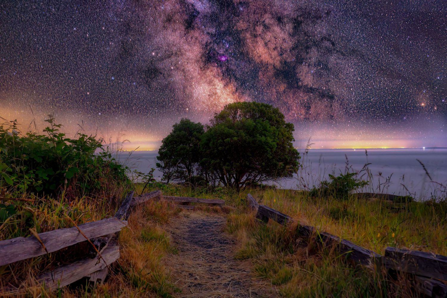 Beautiful night sky panorama showing purple and pink colors over a rural landscape.