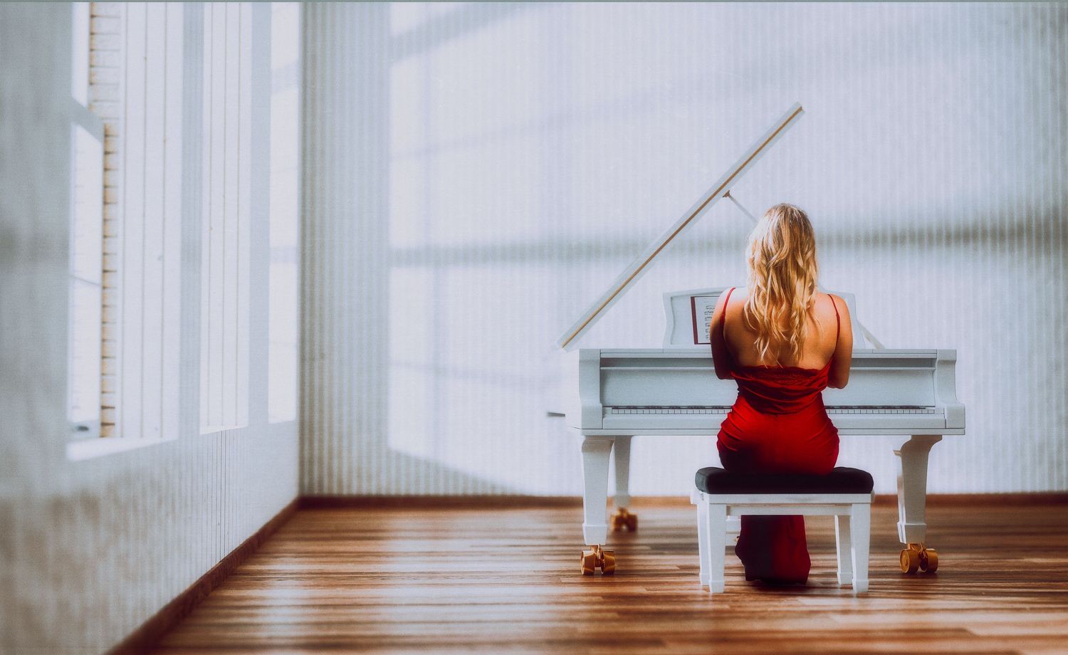 A sequence of images showing someone sitting alone in a bright white corridor on a small bench.