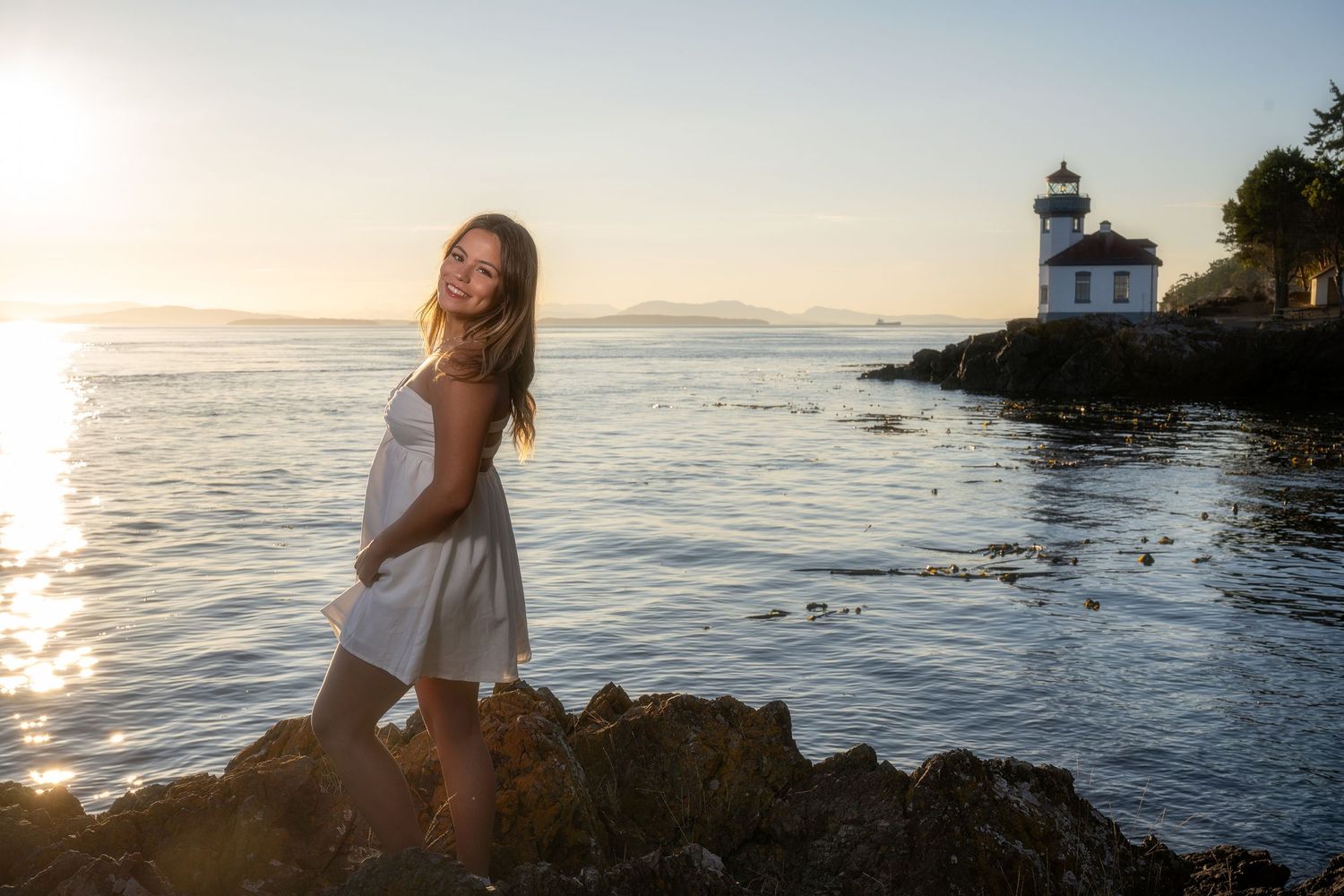 Sunset photoshoot at lighthouse with water and golden hour lighting.