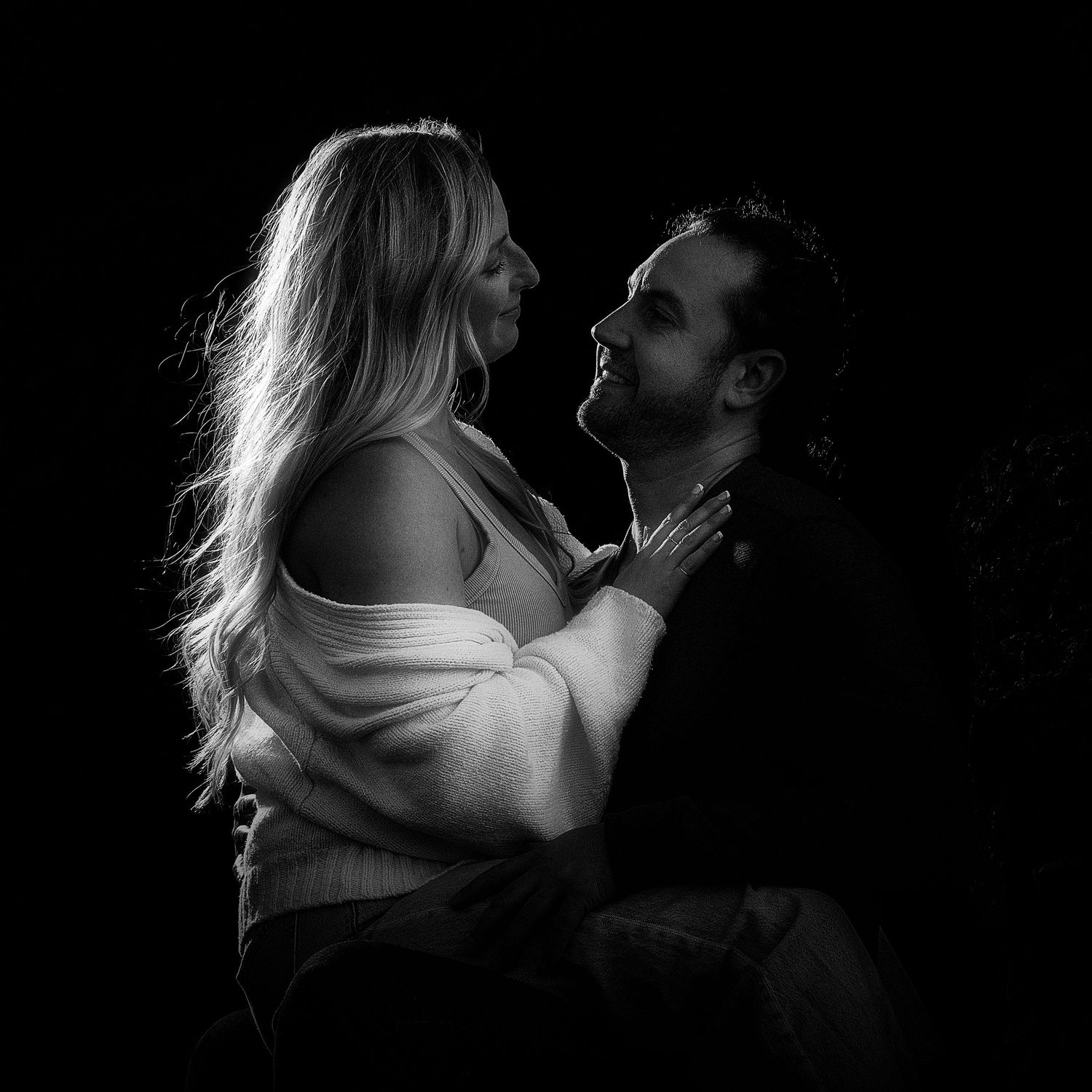 Dramatic black and white intimate couple portraits with rim lighting effects.