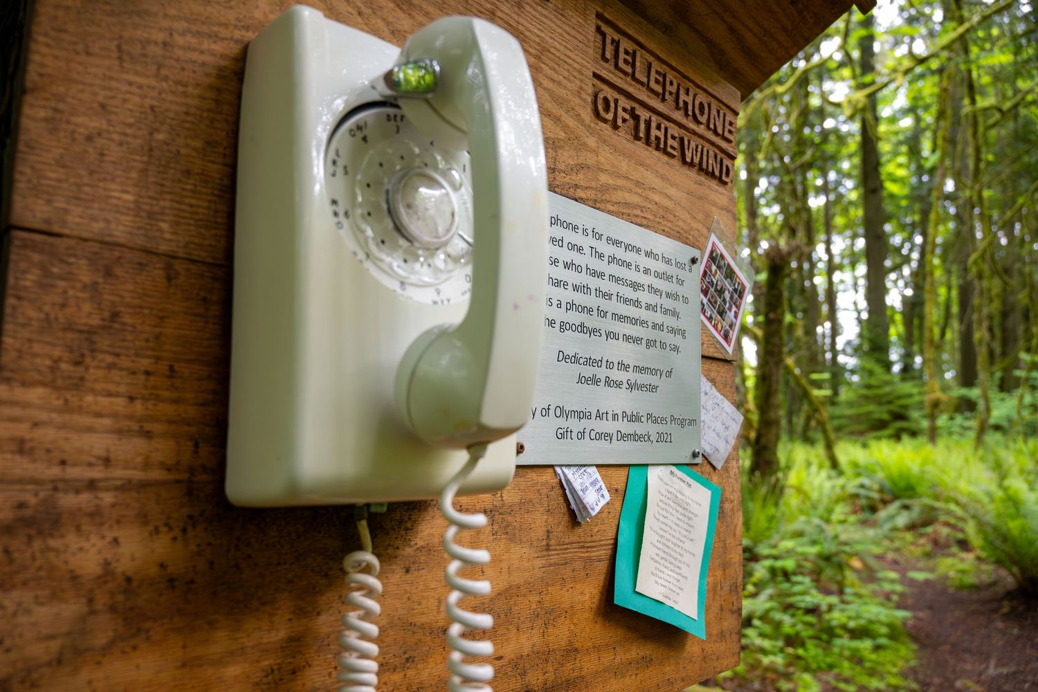 Vintage rotary wall phone mounted on wooden post with 