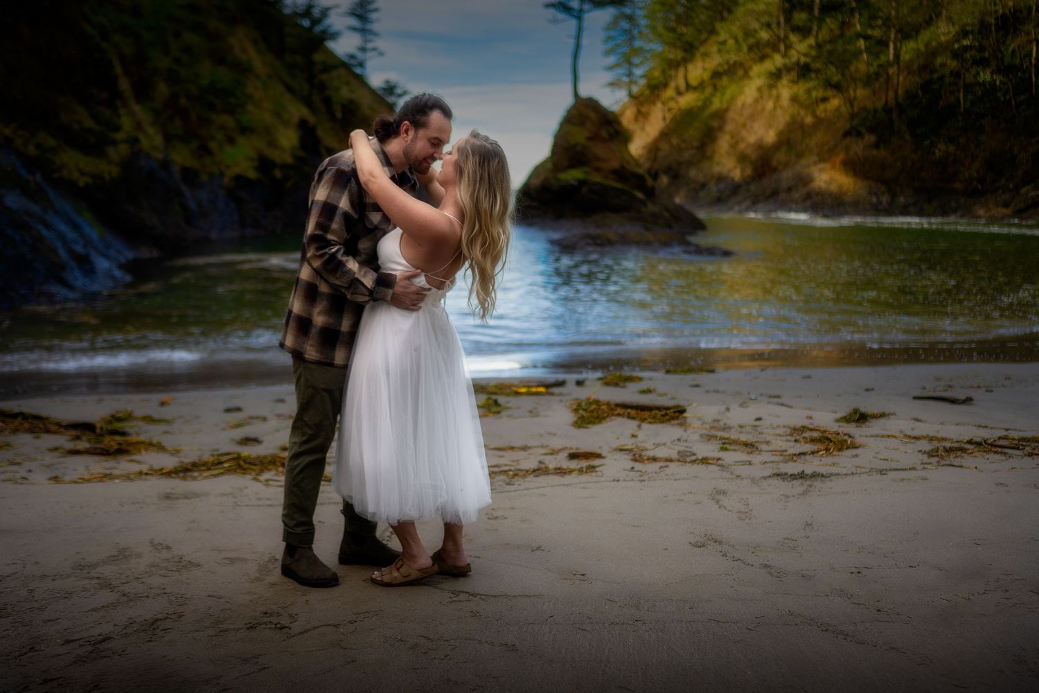 Beach wedding photography session with couple in formal attire on sandy shore.
