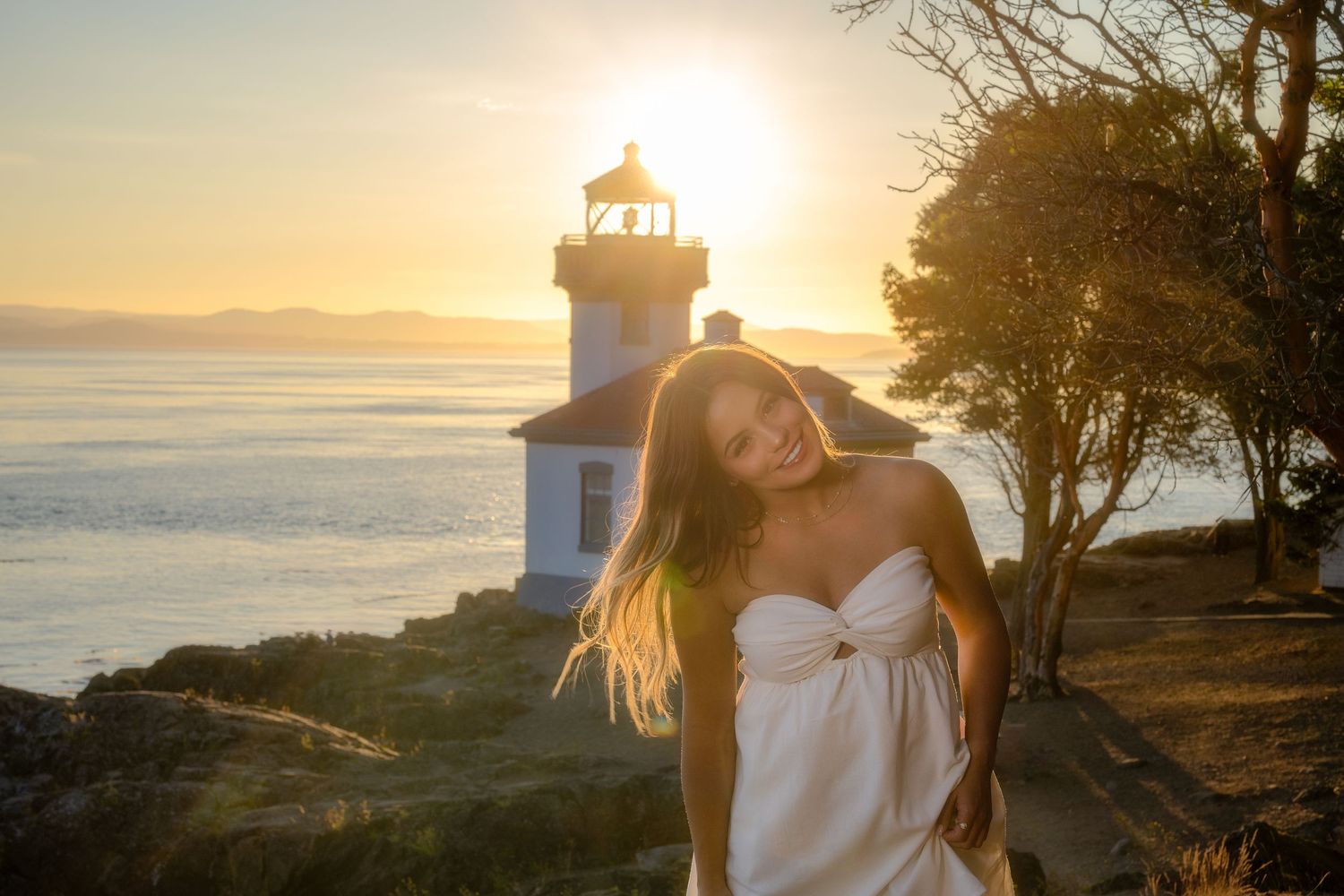 Dreamy sunset portrait by lighthouse overlooking ocean vista.
