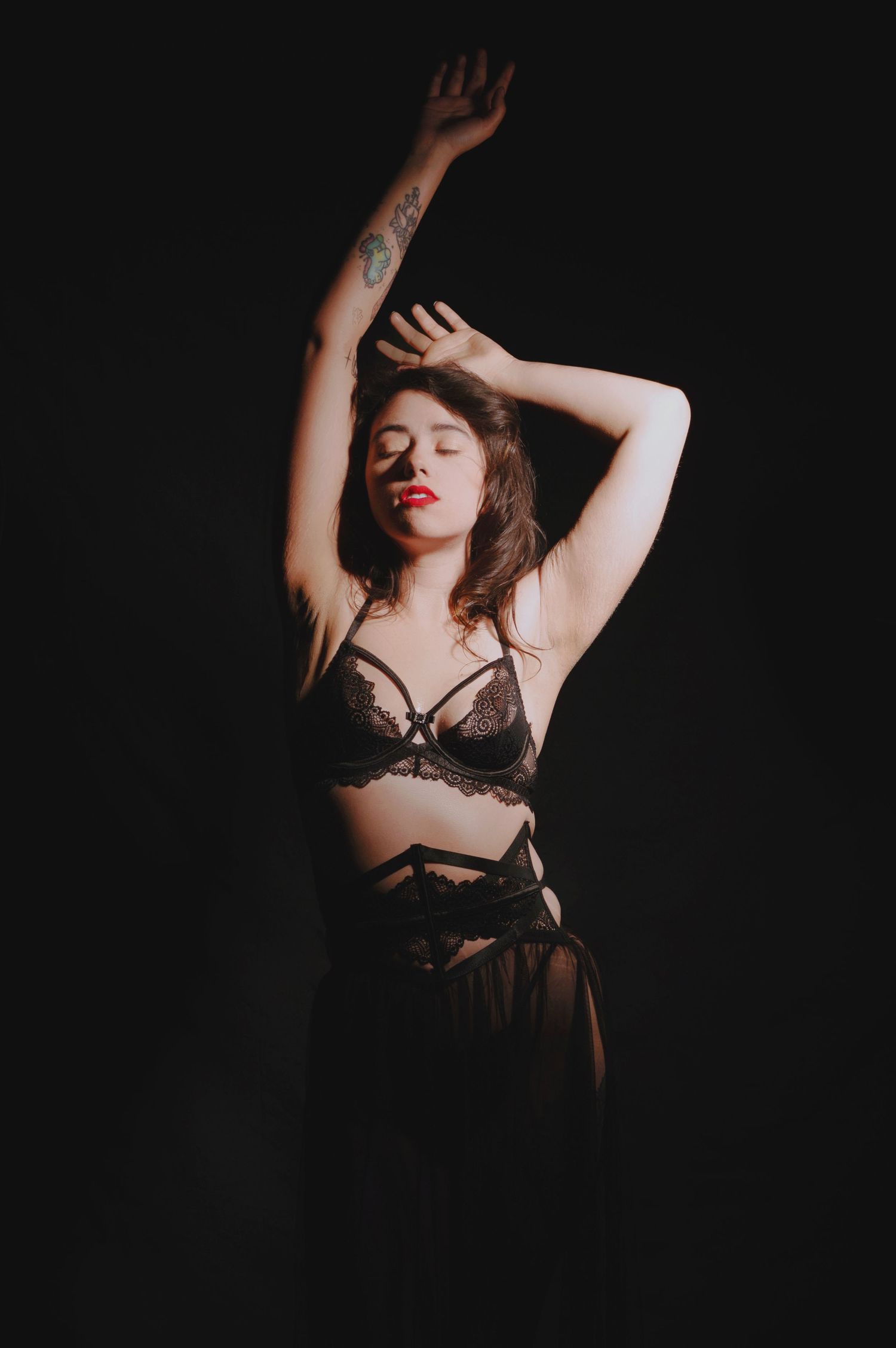 Artistic boudoir photo with dramatic shadows and intimate lingerie styling.
