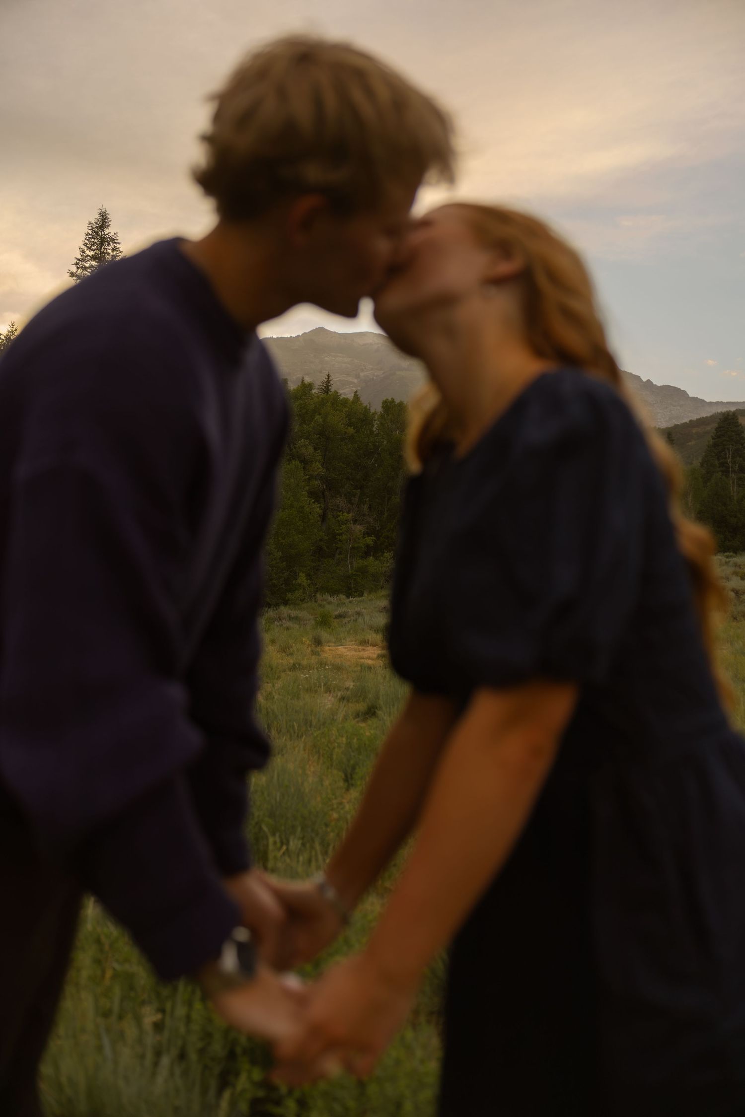 Couple kissing with mountains in focus