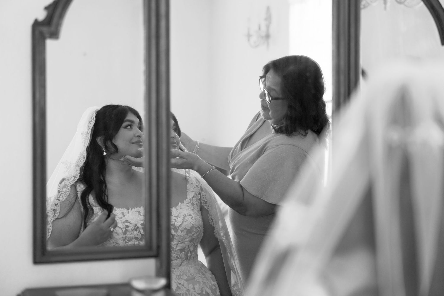 A black and white image of wedding day preparations with a bride getting ready.