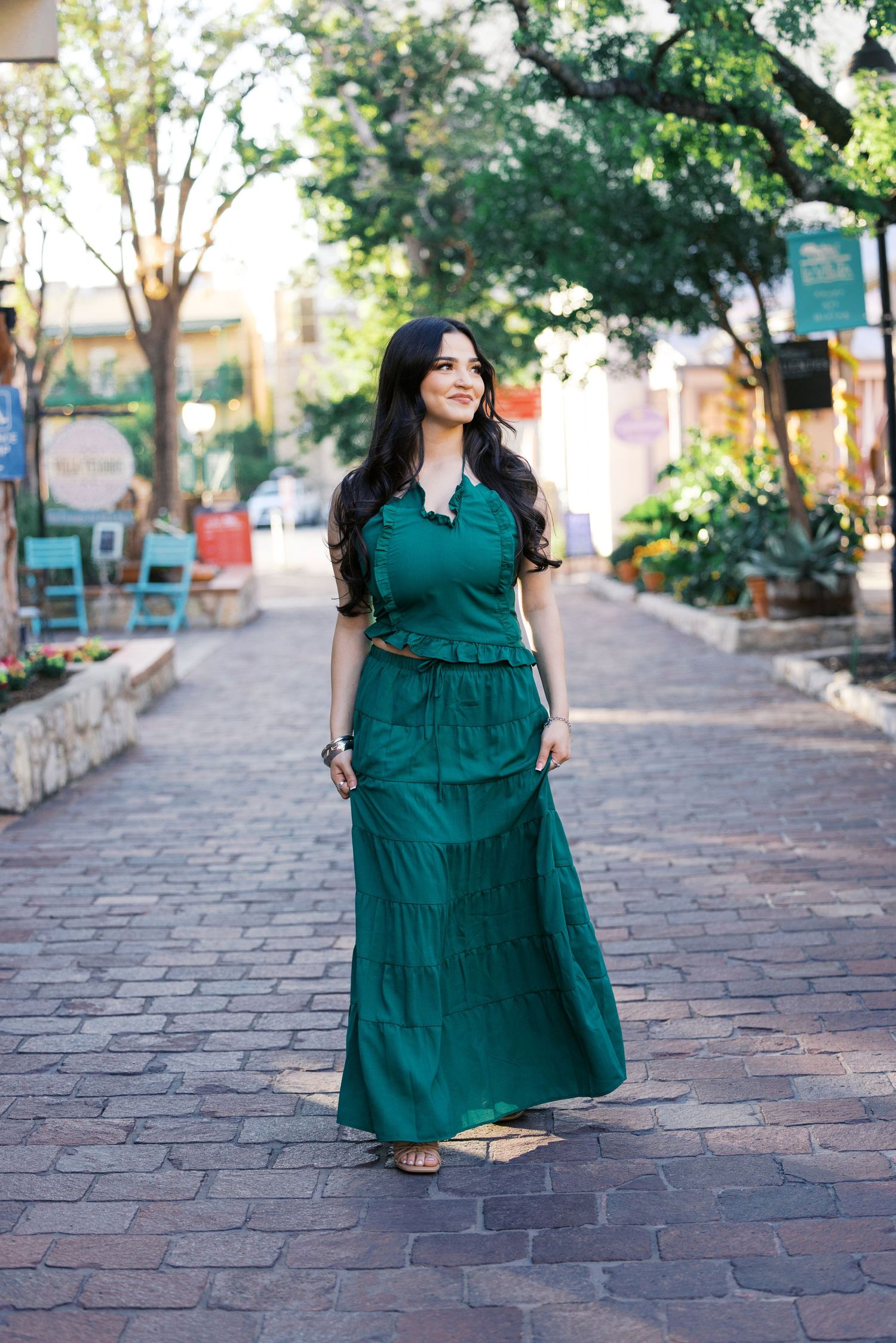 Fashion portraits in flowing green dress on historic brick pathway.