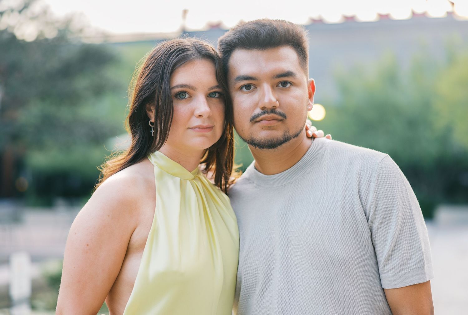Couple in casual attire posing outdoors during a photo session.