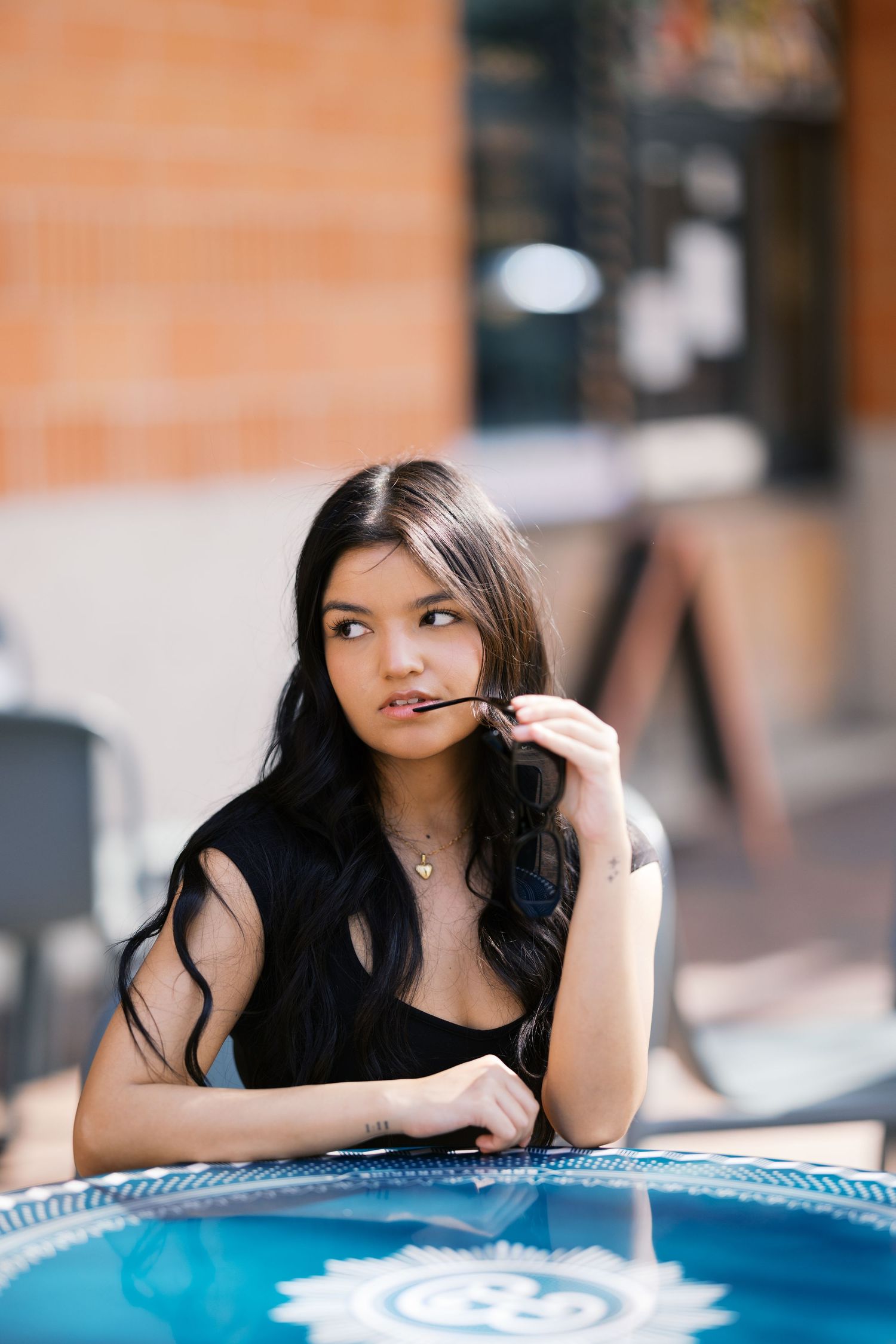 Candid cafe scene with blue table umbrella showing casual summer fashion look.