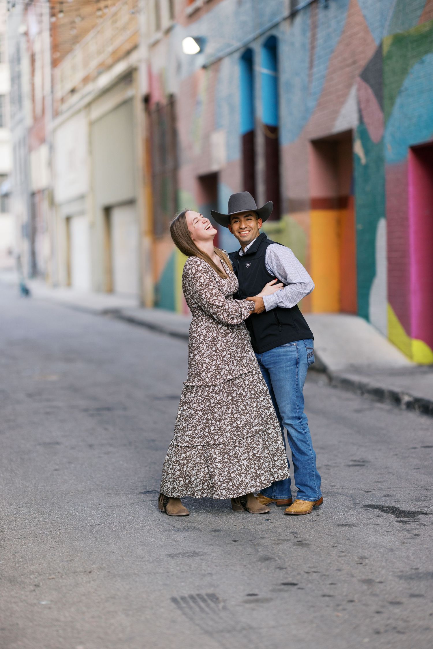 A couple dances together on a colorful urban street.