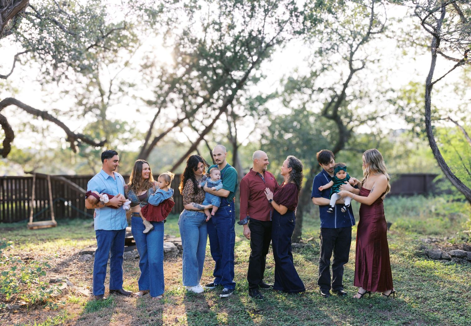 A group photo taken in natural lighting with trees and wooden fencing in the background.