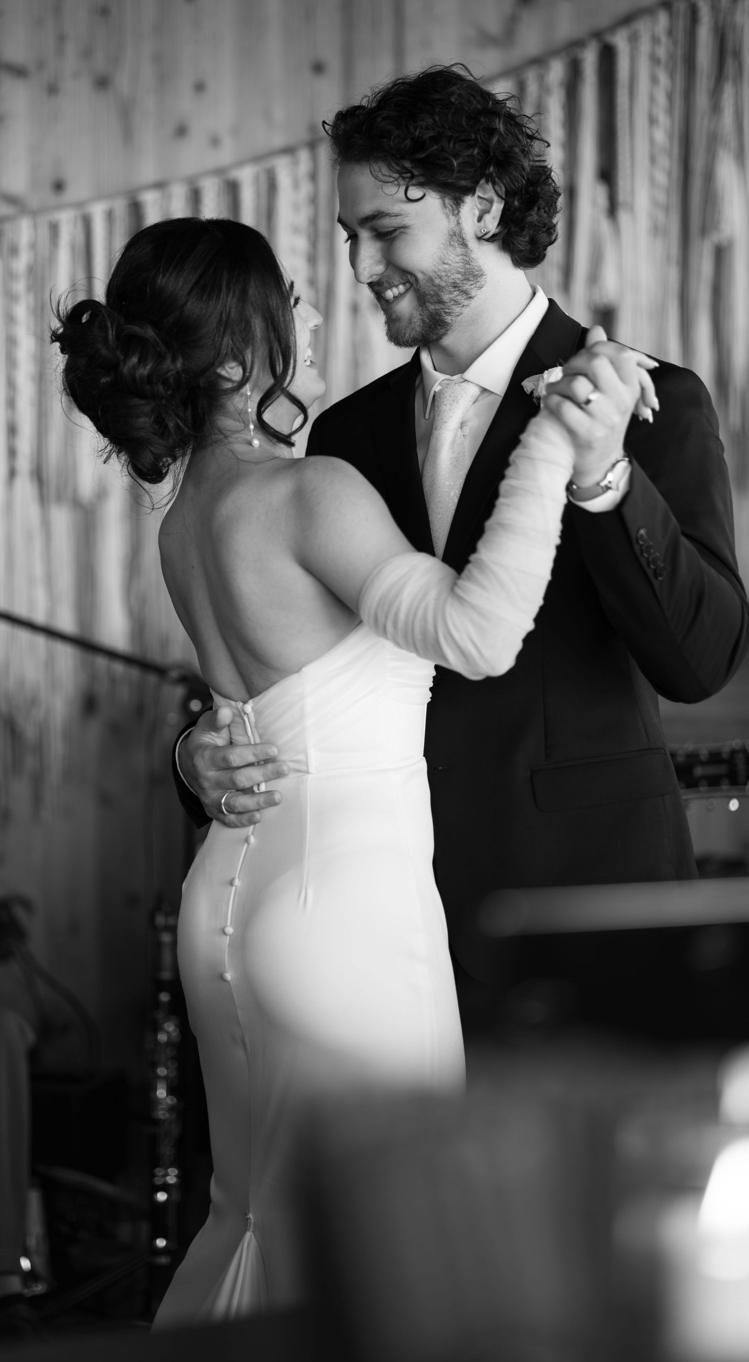 A romantic black and white photo of a couple sharing their first dance at their wedding reception.