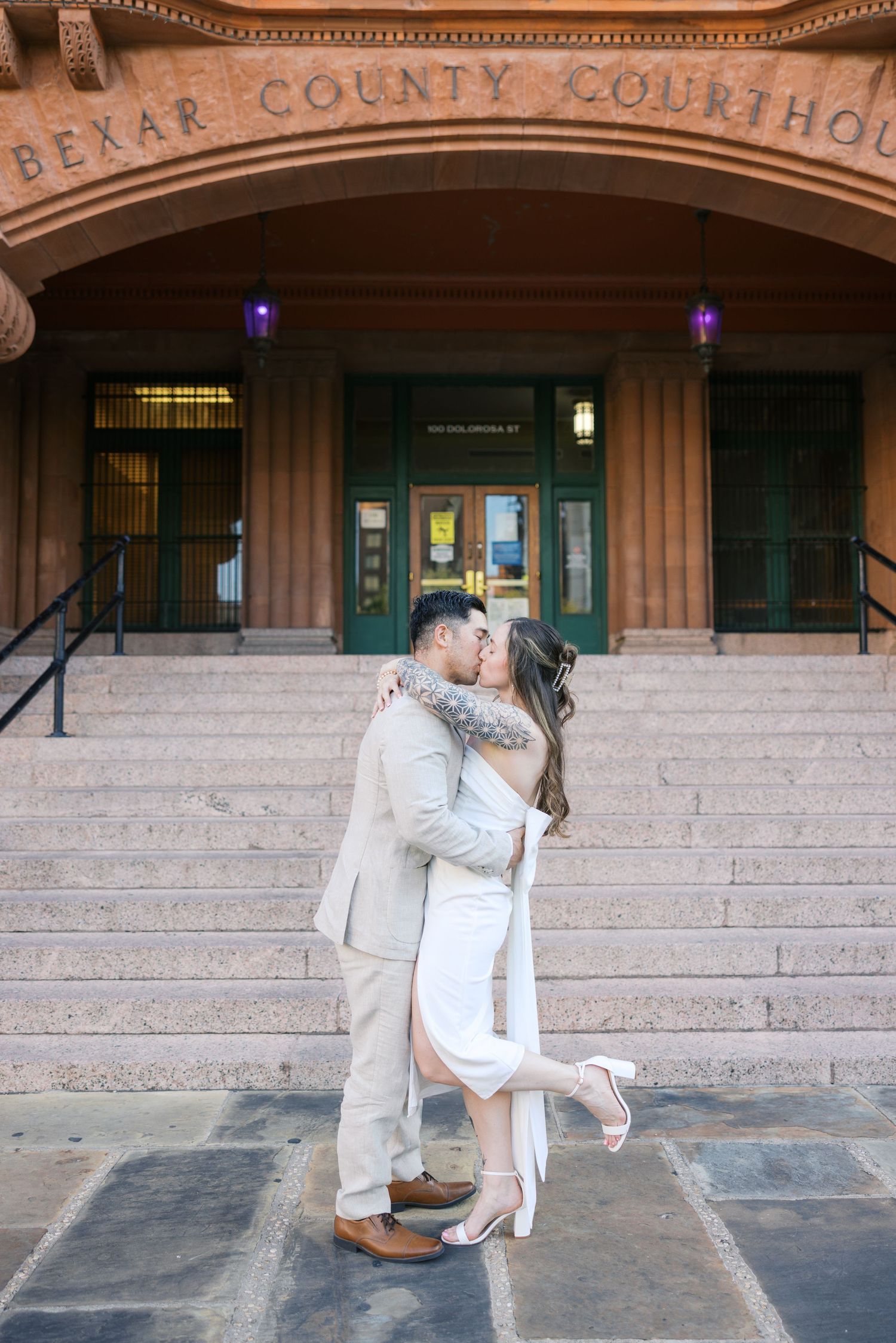 Romantic dance sequence in front of historic courthouse building.